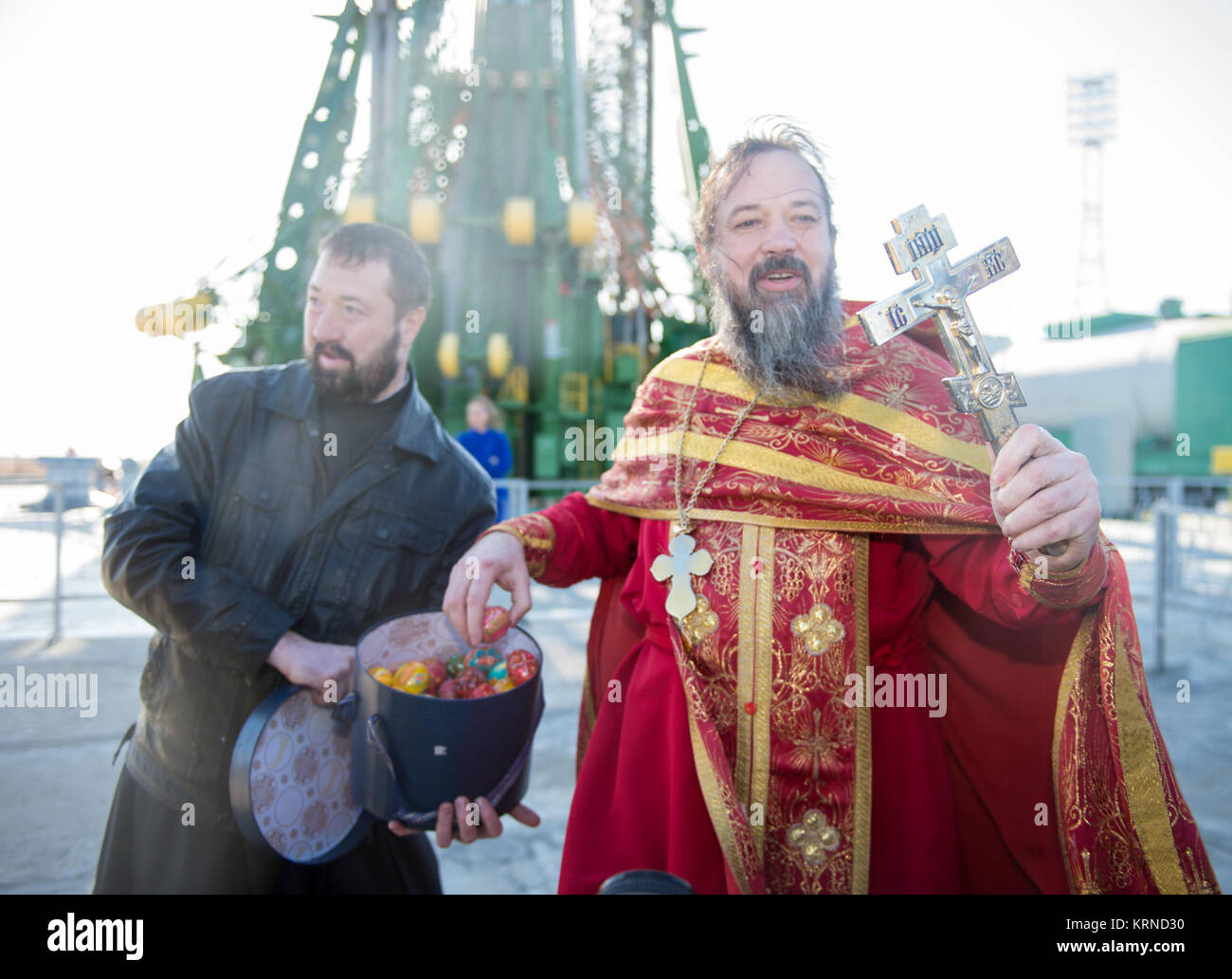 Un sacerdote ortodosso mani uova di Pasqua per i mass media al cosmodromo di Baikonur launch pad dopo la benedizione del razzo Soyuz Mercoledì, Aprile 19, 2017 in Kazakistan. Lancio del razzo Soyuz è prevista per il mese di aprile 20 Cosmodromo di tempo e porterà Expedition 51 Soyuz Commander Fyodor Yurchikhin di Roscosmos e tecnico di volo Jack Fischer della NASA in orbita per iniziare i loro quattro e una metà mese missione sulla Stazione spaziale internazionale. Photo credit: (NASA/Aubrey Gemignani) Expedition 51 Soyuz benedizione (NHQ201704190004) Foto Stock