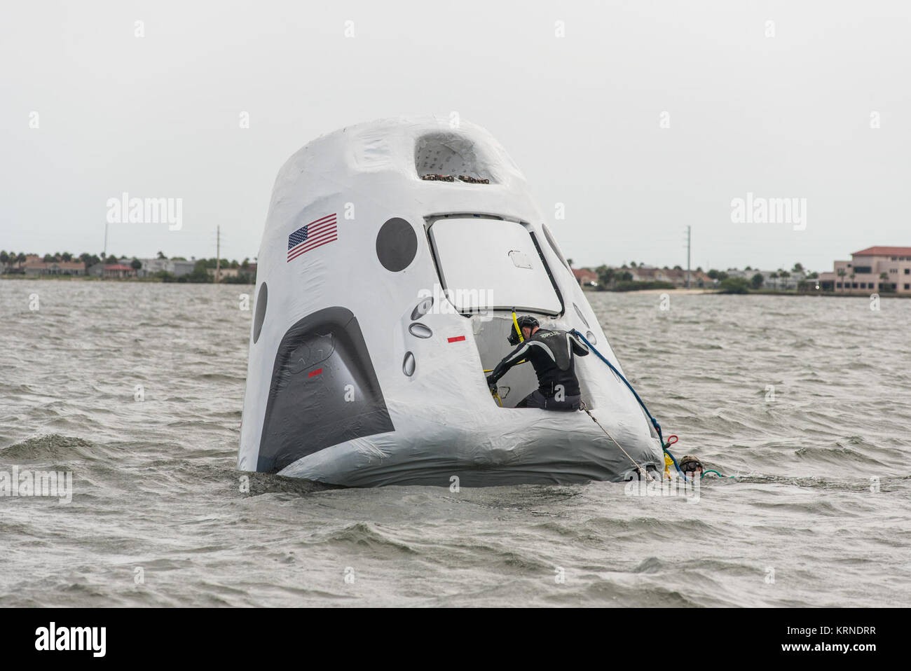 Personale dalla NASA, SpaceX e gli Stati Uniti Air Force hanno iniziato la pratica di operazioni di recupero per l'equipaggio SpaceX Dragon. Utilizzando un full-size modello di veicolo spaziale che porterà gli astronauti sulla Stazione spaziale internazionale, Air Force parajumpers pratica aiutare gli astronauti al di fuori dell'equipaggio SpaceX Dragon a seguito di una missione. In alcuni inusuali situazioni di ripristino, SpaceX potrebbero avere la necessità di lavorare con Air Force per parajumpers per recuperare gli astronauti dalla capsula a seguito di un atterraggio in acqua. Il trainer di recupero è stato recentemente abbassato nella laguna del fiume Indian nei pressi di NASA Kennedy Space Center consentendo Foto Stock
