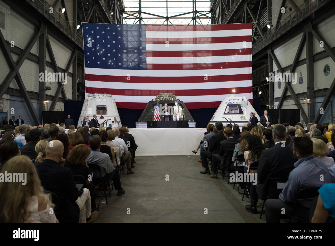 Vice Presidente Mike Pence parla davanti a un pubblico di dirigenti della NASA, gli Stati Uniti e il governo della Florida i funzionari e i dipendenti all'interno del complessivo del veicolo la costruzione presso NASA Kennedy Space Center in Florida. Pence ha ringraziato i dipendenti per far avanzare la leadership americana nello spazio. A ridosso del podio sono, da sinistra, un volato SpaceX Dragon capsula, il veicolo spaziale Orion volato su Esplorazione prova di volo-1 nel 2014, e un mockup del Boeing CST-100 Starliner. Durante la sua visita a Kennedy, il Vice Presidente ha anche visitato diverse strutture evidenziando i partenariati pubblico-privato, in quanto sia la NASA e commerciale Foto Stock
