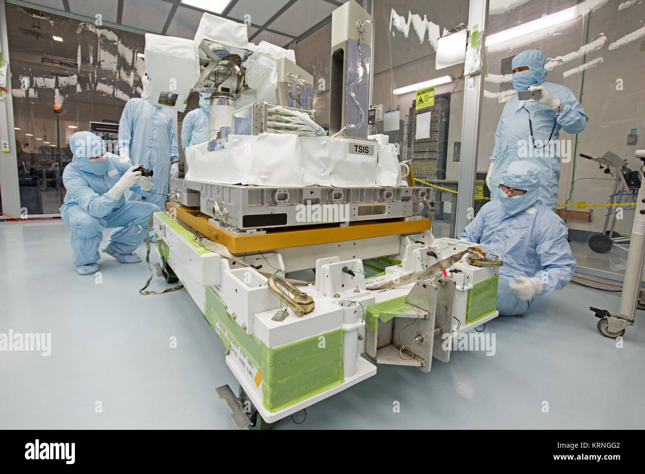 Nella baia di alta del Kennedy Space Center Space Station Processing Facility, Chris Hardcastle, a sinistra delle tecnologie Stinger-Ghaffarian e altri payload i membri del team esegue lo strumento spacewalk fit-controlli del totale integrato e spettrale di irradiamento solare sensore-1 (STI-1) payload e il Pallet EXPRESS adattatore. Sti-1 è progettato per misurare l'energia del sole in ingresso nella Terra da vedere come essa è distribuita su diverse lunghezze d'onda di luce. Queste misurazioni aiutare gli scienziati a stabilire la massa totale dell'energia e di come il nostro pianeta atmosfera dell risponde alle modifiche di l'energia del Sole uscita. Sti Foto Stock