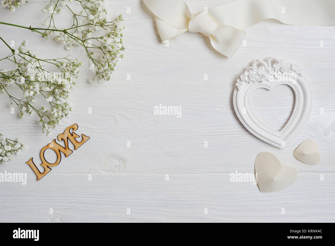 Mock up Composizione di fiori bianchi in stile rustico, cuori e un regalo per il giorno di San Valentino con un posto per il vostro testo. Piatto, laici top view photo mock Foto Stock