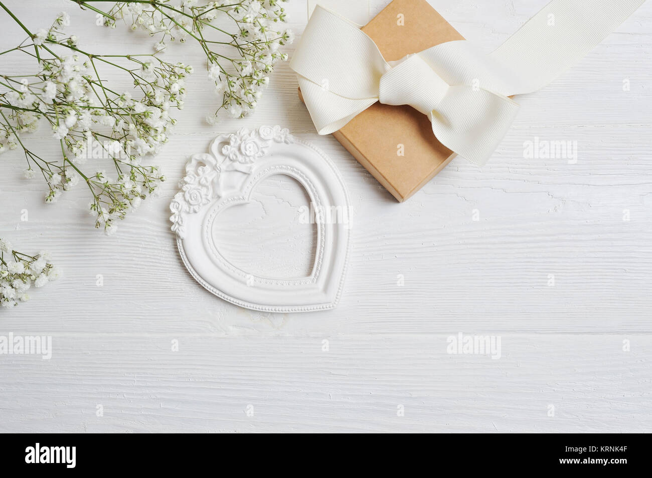 Mock up Composizione di fiori bianchi in stile rustico, cuori di amore e un regalo per il giorno di San Valentino con un posto per il vostro testo. Piatto, laici top view foto Foto Stock