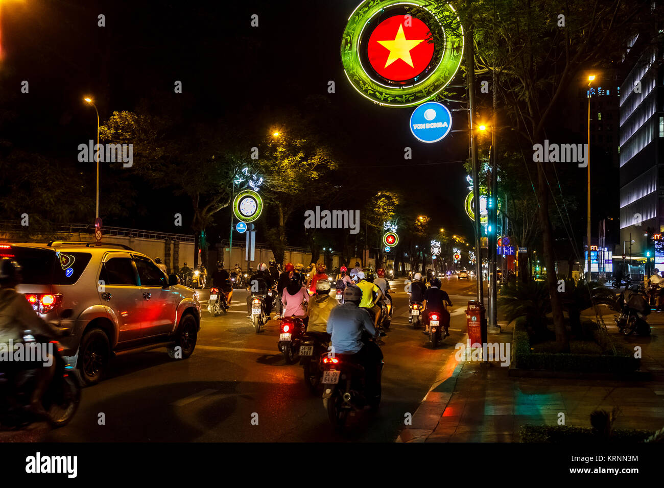 Busy street nel centro di Saigon (Ho Chi Minh City), Vietnam del sud, sud-est asiatico: street scene di notte, insegne luminose, tipico moto Foto Stock