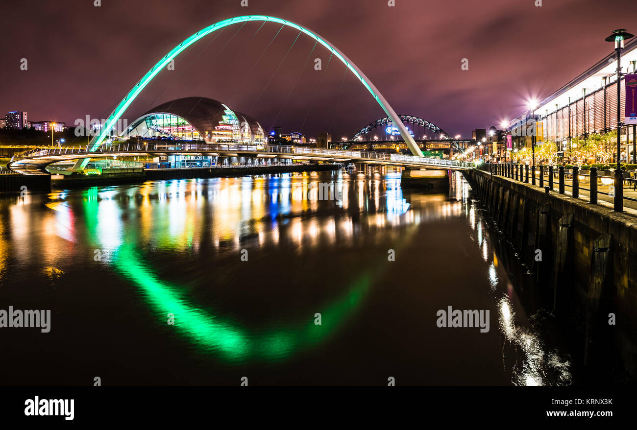 Notte foto guardando lungo il Fiume Tyne verso Gateshead Millennium Bridge con Tyne Bridge in background, Newcastle upon Tyne, Inghilterra Foto Stock