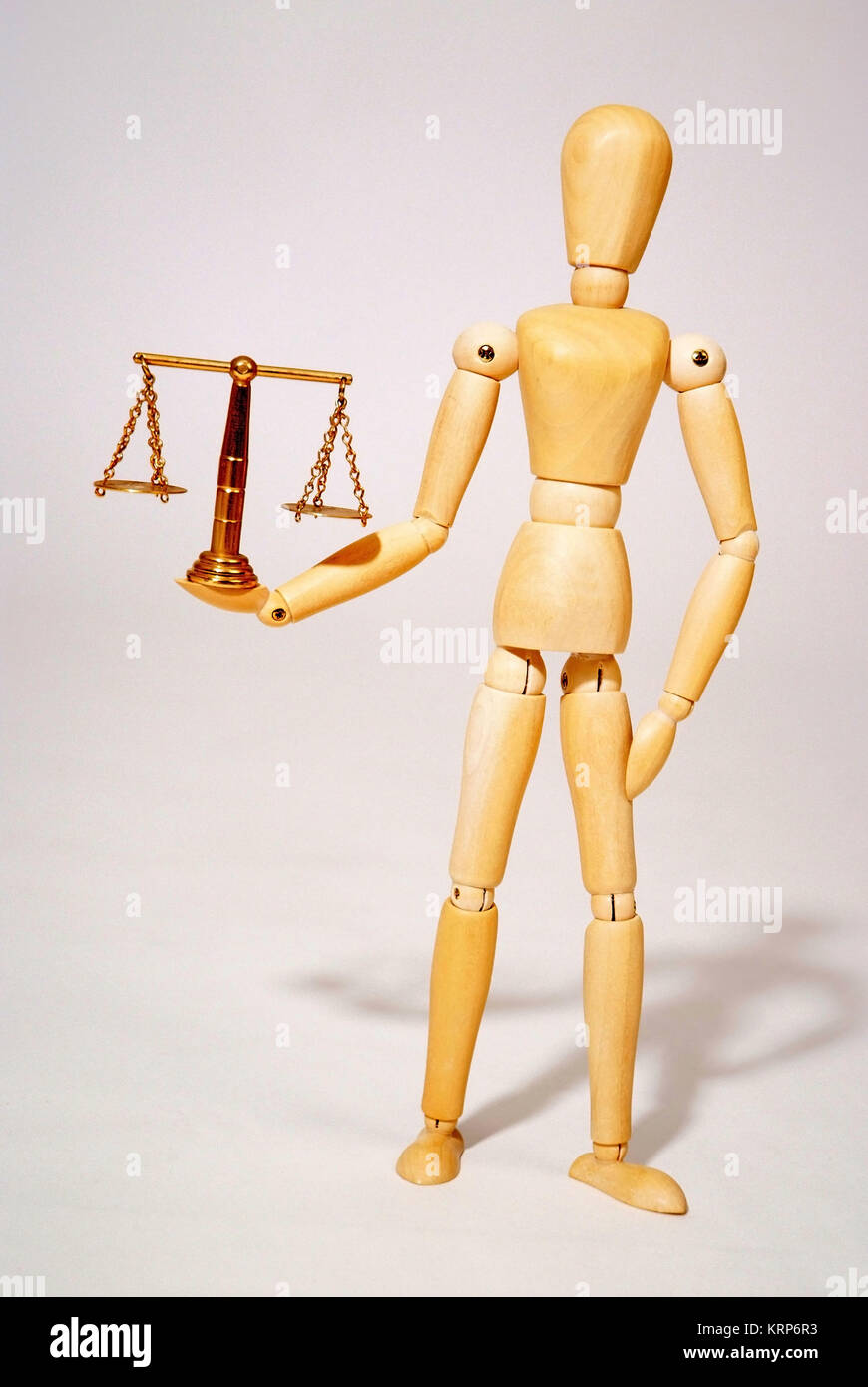 Holzpuppe mit Messingwaage, Symbolbild Gerechtigkeit - bambola articolata con scala Foto Stock
