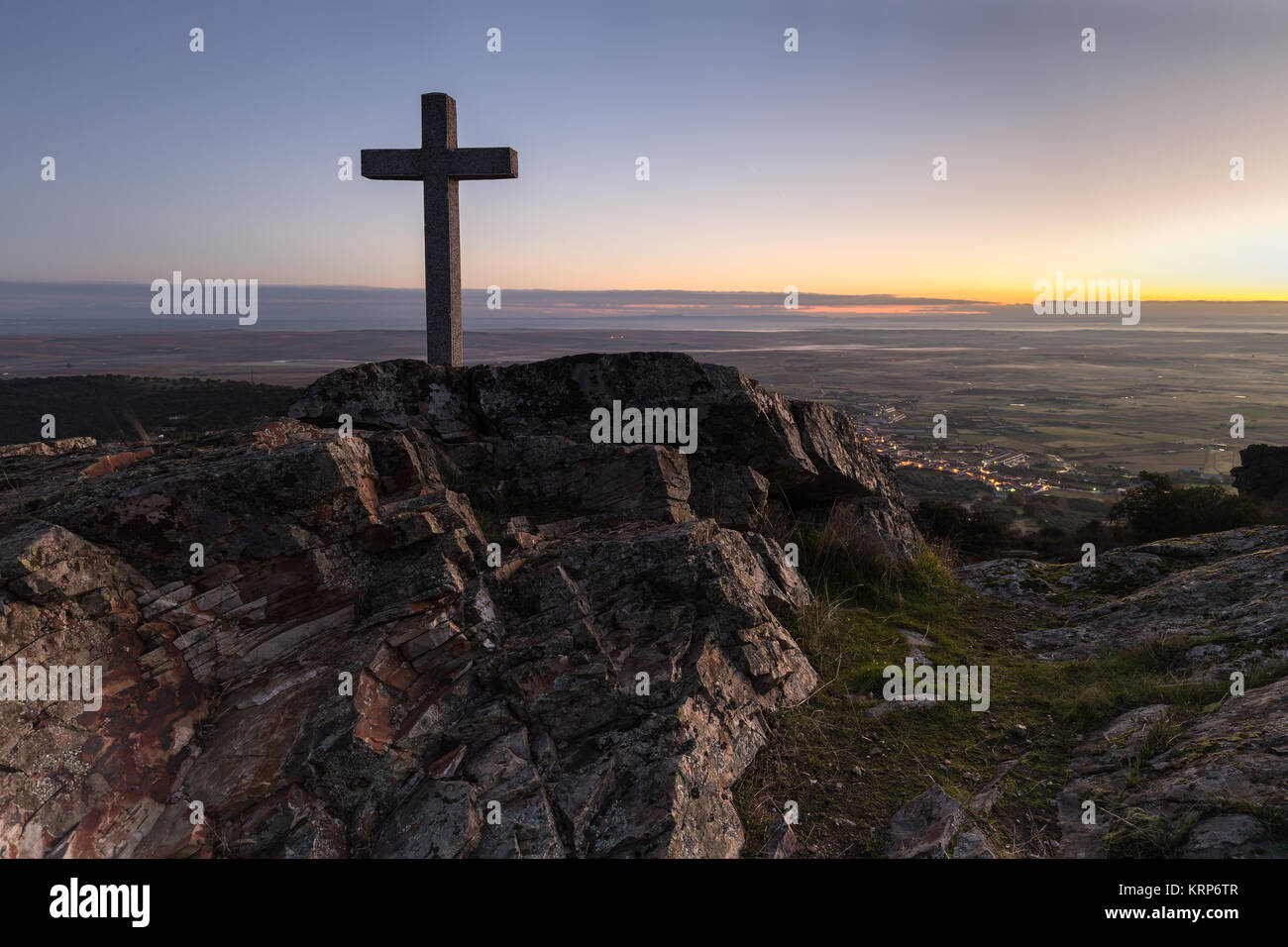 Alba con croce in primo piano accanto alla Sierra de Fuentes. Spagna. Foto Stock