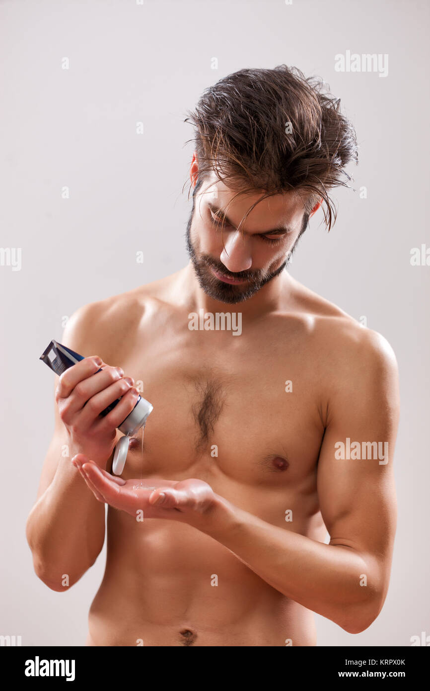 Giovane uomo è l'applicazione di gel per capelli per i suoi capelli. Foto Stock