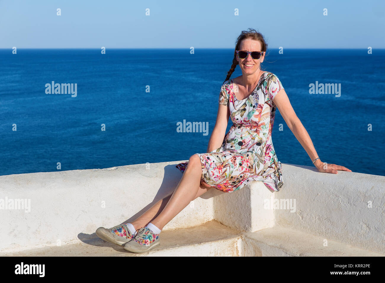 Caucasian donna di mezza età come turista con il mare blu Foto Stock