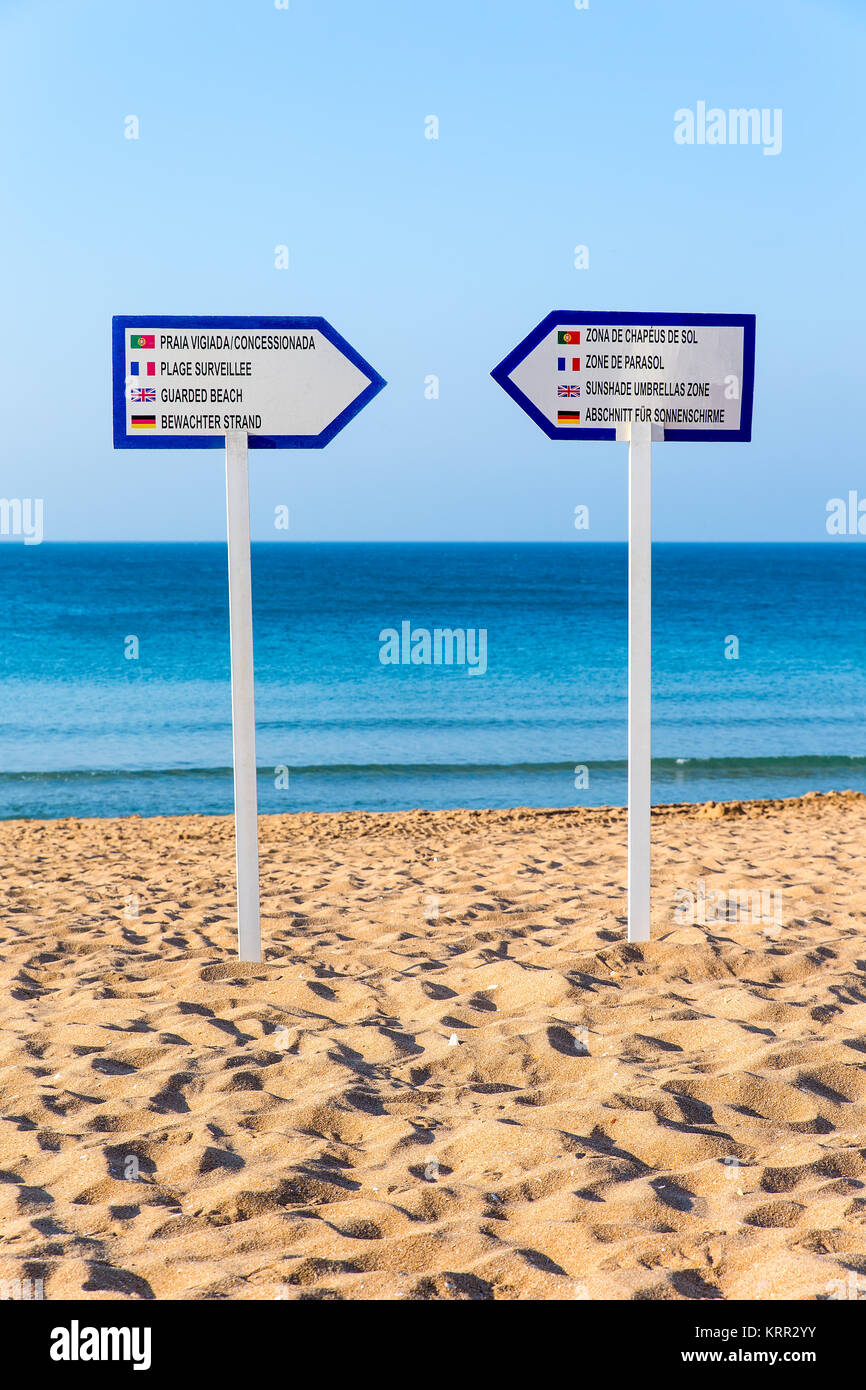 Due segnali di informazione riposare sulla spiaggia di sabbia di mare Foto Stock