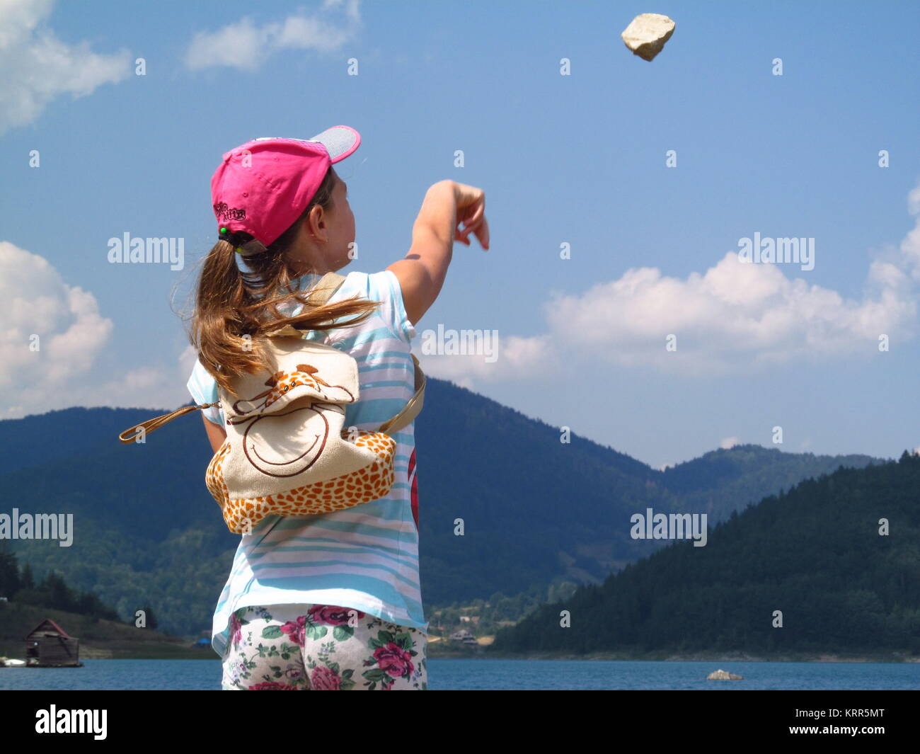Una ragazza lanciando un rock Foto Stock
