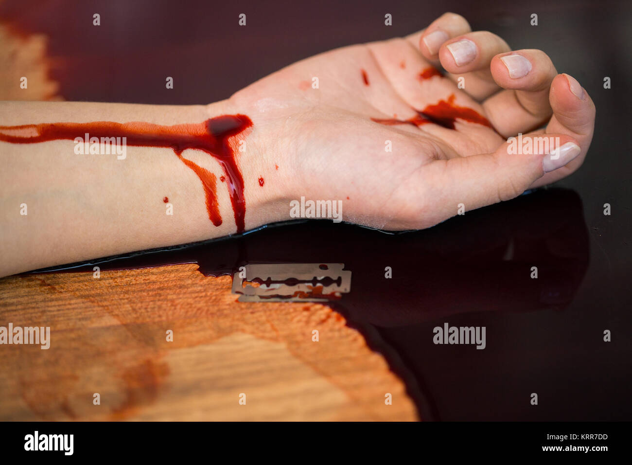 Donna morta la mano nel sangue sul pavimento in corrispondenza della scena del crimine Foto Stock