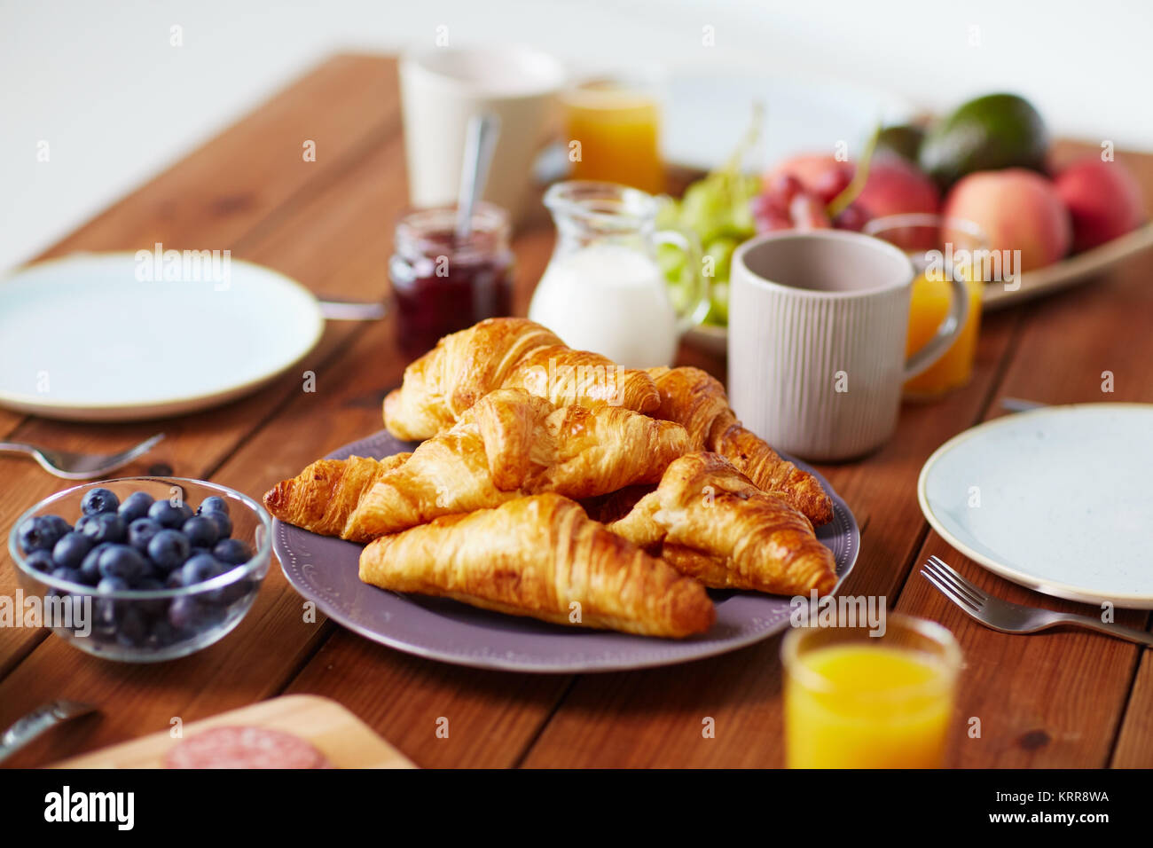 Piastra del croissant su un tavolo di legno a colazione Foto Stock