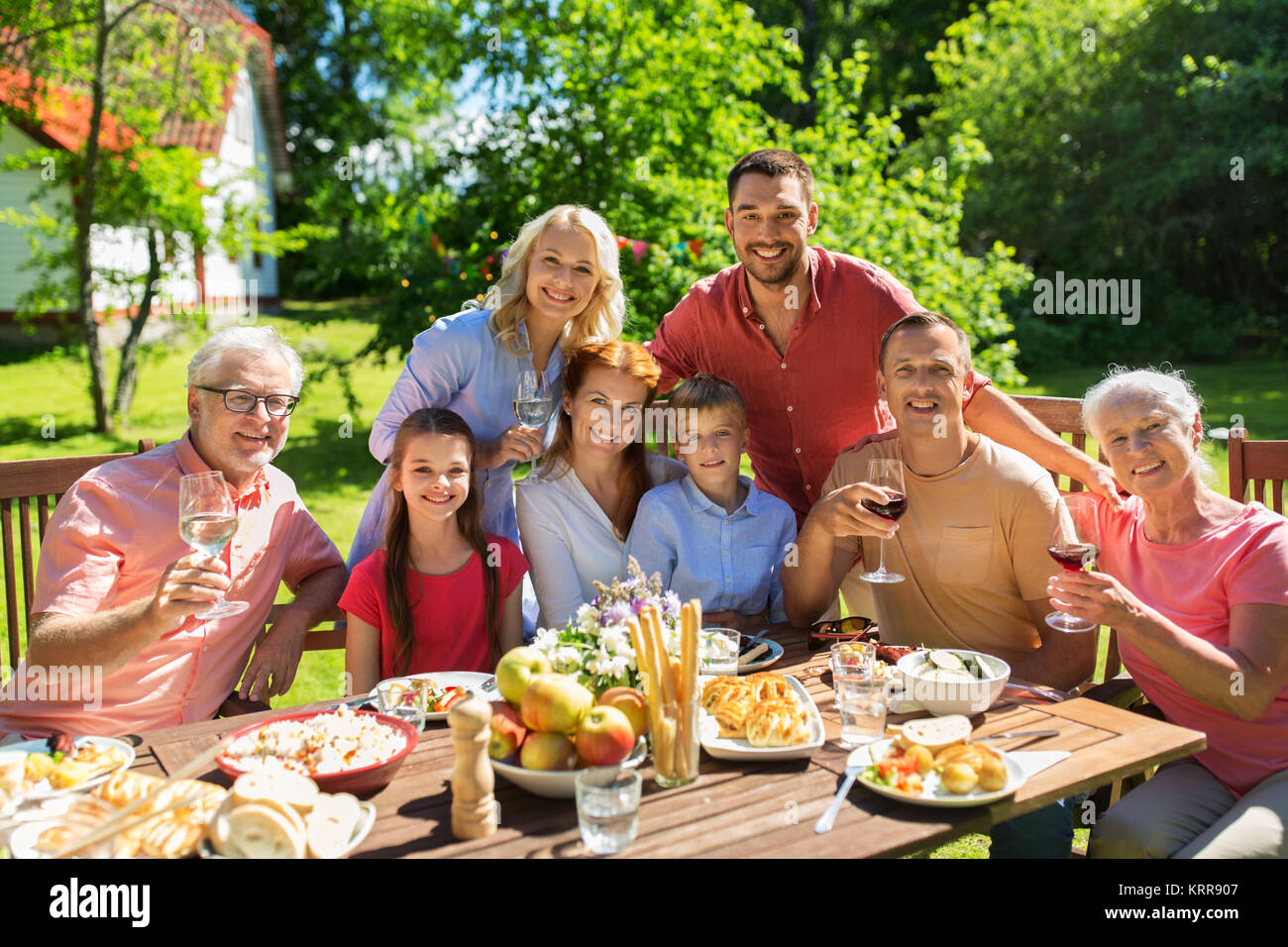 La famiglia felice di consumare la cena o summer party in giardino Foto Stock