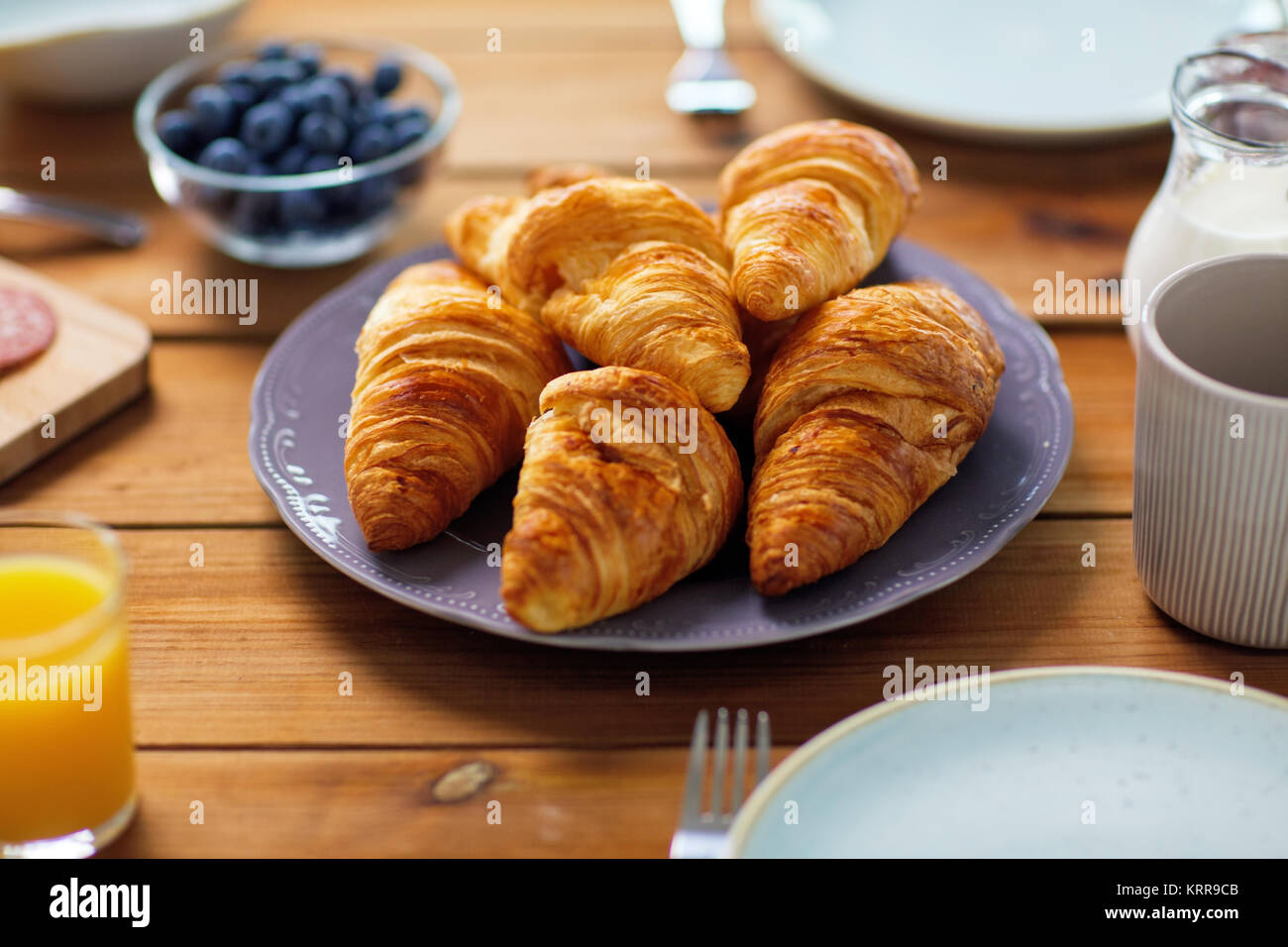 Piastra del croissant su un tavolo di legno a colazione Foto Stock