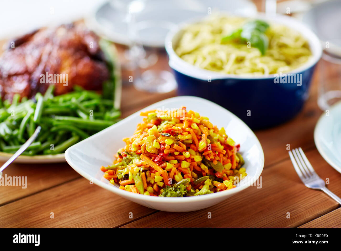 Insalata di verdure con mais e altri prodotti alimentari su tavola Foto Stock