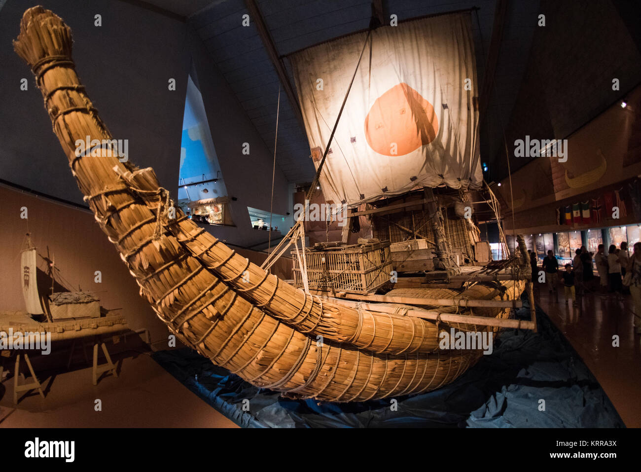 Barca di papiro Ra II Thor Heyerdahl Espedizione transatlantica Museo Kon-Tiki Oslo Norvegia | OSLO, Norvegia — La prua di papiro del Ra II si incurva verso il cielo sotto la sua vela con emblema solare nell'ala del 1978 del Museo Kon-Tiki. Il suo equipaggio di sette uomini, navigando sotto la bandiera delle Nazioni Unite nel 1970, ha agito anche come scienziati cittadini, registrando catrame e detriti di plastica attraverso l'Atlantico in uno dei primi sondaggi sulla contaminazione oceanica. Lo scafo di giunchi stesso attingeva sia dalle tradizioni andine che da quelle egizie antiche nella costruzione navale. Foto Stock