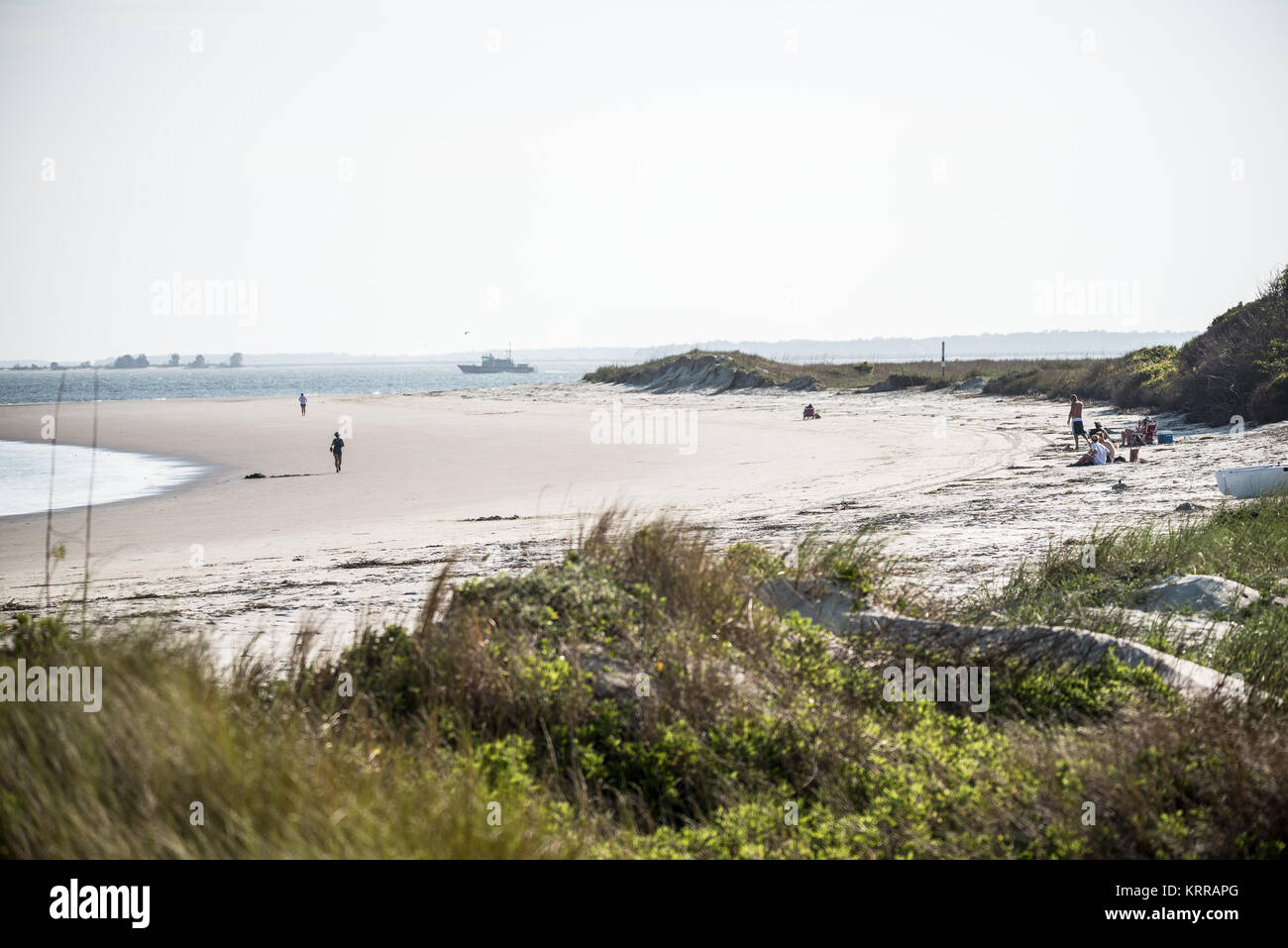 Sullivan's Island Beach South Carolina // SULLIVAN'S ISLAND, South Carolina, Stati Uniti - l'estremità meridionale di Sullivan's Island presenta un'ampia e incontaminata spiaggia con ampie vedute dell'Oceano Atlantico. Questa tranquilla zona costiera fa parte di un'isola barriera situata all'ingresso del porto di Charleston. Sullivan's Island combina bellezza naturale e significato storico, in quanto era il punto di ingresso per circa il 40% degli schiavi africani portati in America del Nord britannico. L'isola è conosciuta per i suoi sforzi di conservazione, con sistemi di dune protette e foreste marittime. Visitatori Foto Stock