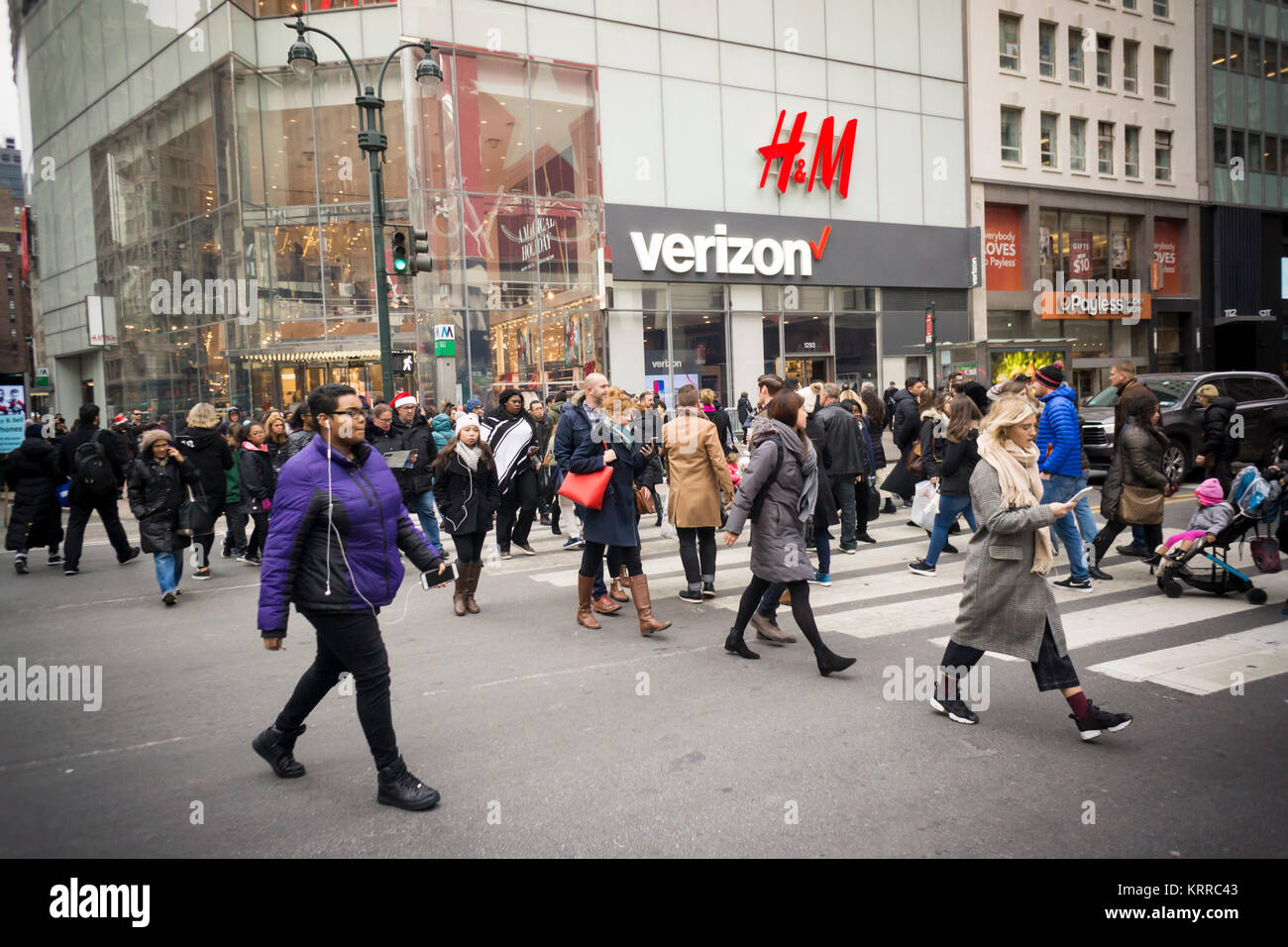 Shopping di Natale i pedoni cross Herald Square di fronte a Verizon Wireless store e un H&M department store di New York Martedì, Dicembre 12, 2017. (© Richard B. Levine) Foto Stock