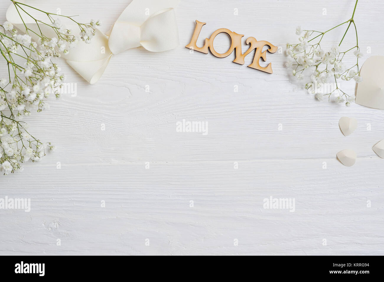 Mockup fiori composizione da un regalo bianca gypsophila con un cuore e un'iscrizione amore in bianco sullo sfondo di legno. Il giorno di San Valentino. Piatto, laici per Foto Stock