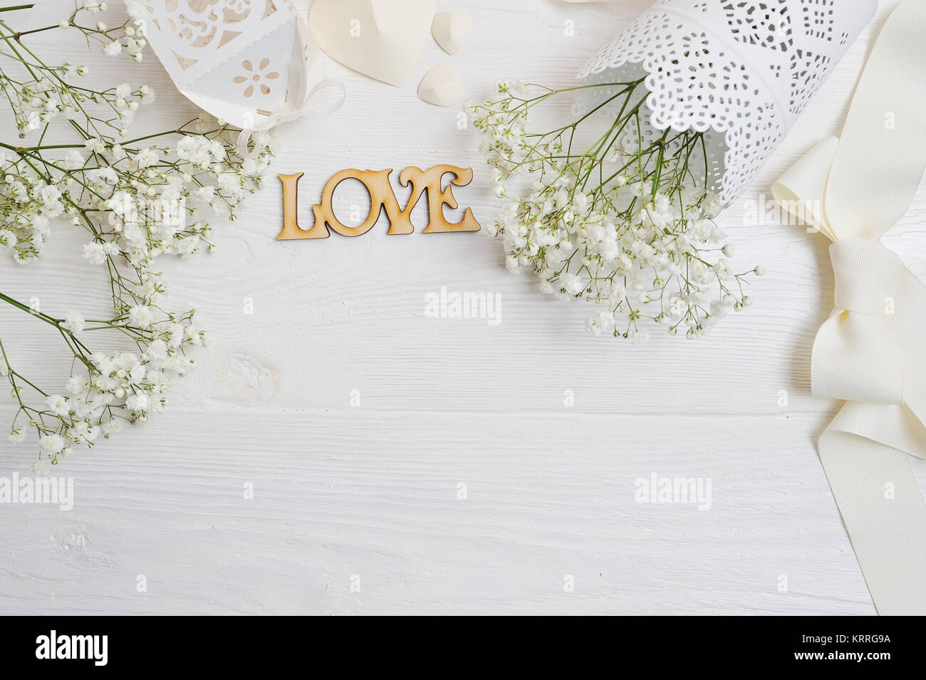 Mock up Composizione di fiori bianchi in stile rustico, cuori e un regalo per il giorno di San Valentino con un posto per il vostro testo. Piatto, laici top view photo mock Foto Stock