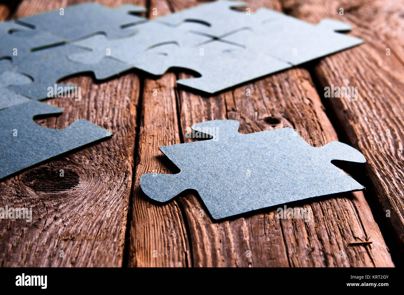 Puzzle incompleto giacente sul rustico in legno pannelli. Foto Stock