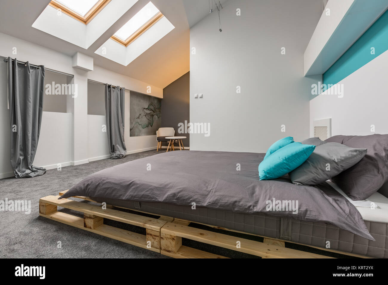 Semplice camera mansardata con pallet diy bed e finestre a soffitto Foto Stock