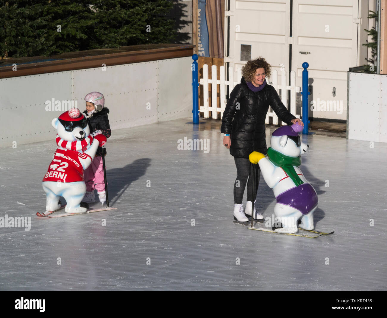 La madre e la bambina figlia Münchener EisZauber Monaco di Baviera la magia di ghiaccio Ice Rink di tenere su orso telai di sci per arrestare la caduta Stachus Karlsplatz Mu Foto Stock