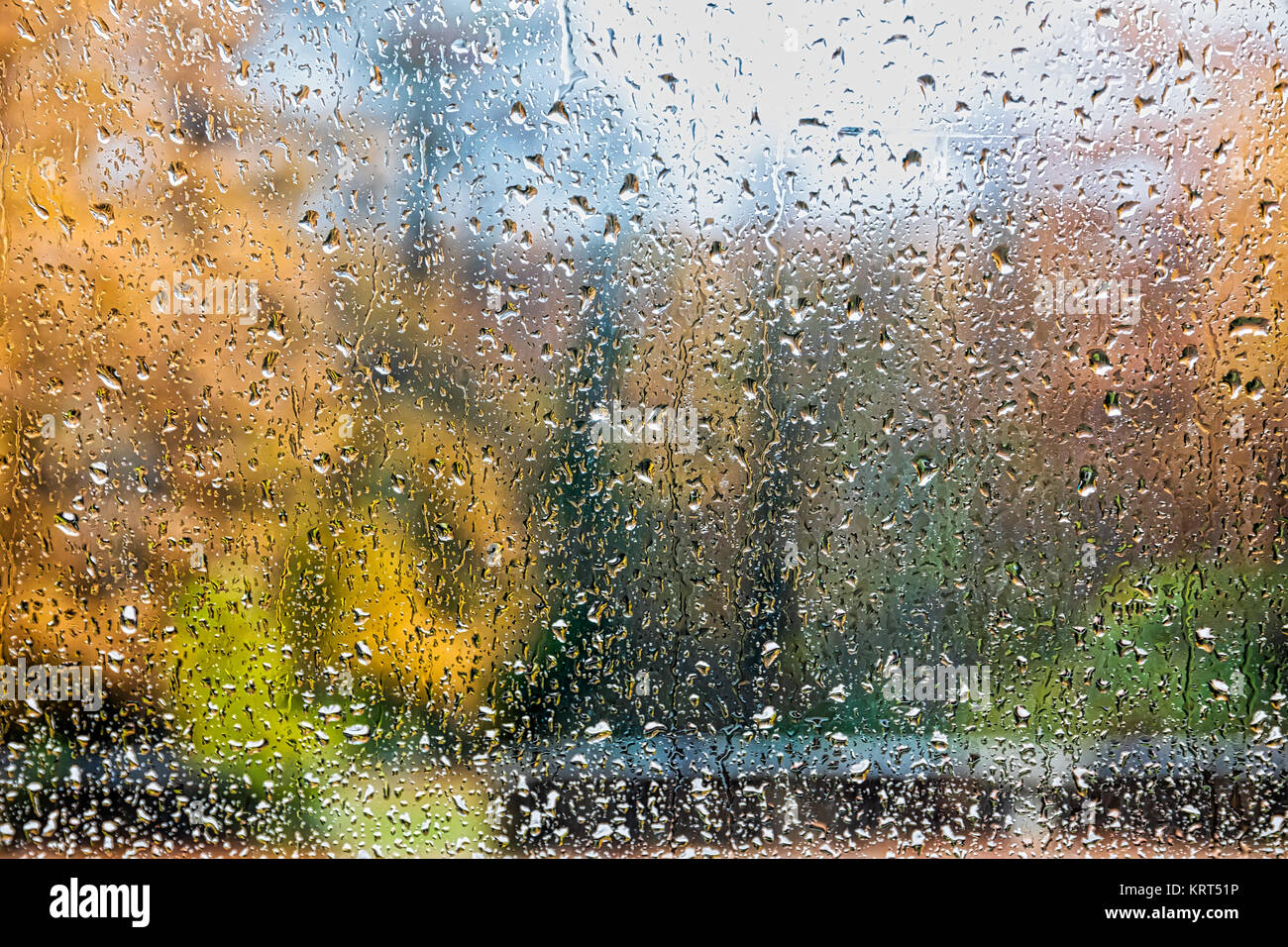 La pioggia nel parco di vetro superficie bagnata con la riflessione delle gocce di pioggia sulla finestra inzuppato di vetro, finestra di sfondo in autunno park, in autunno piovoso terra Foto Stock