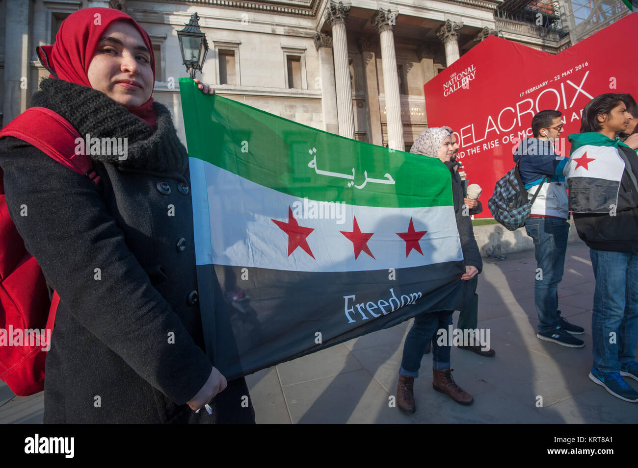 Le donne in attesa di un libero bandiera siriana a 'Cibo non bombe' per la Siria protesta in Trafalgar Square. Foto Stock