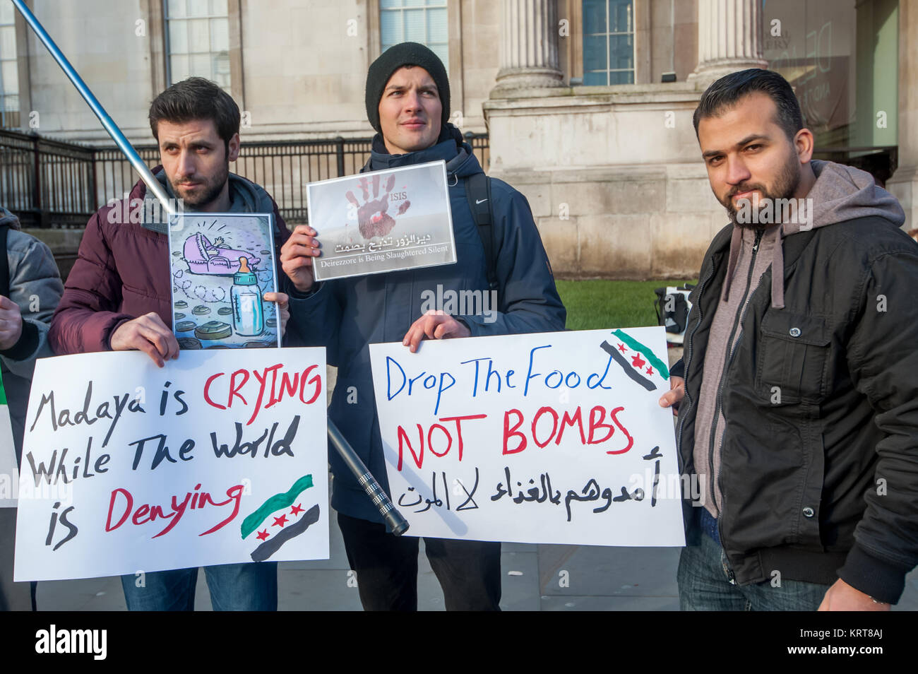 Gli uomini detengono posters 'Malaya è il pianto mentre il mondo è negare l' e 'Drop il cibo non bombe' alla protesta siriano in Trafalgar Square. Foto Stock