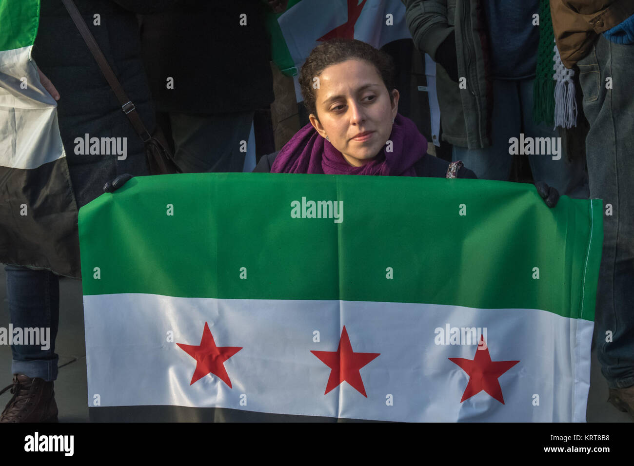 Una donna che tiene una libera bandiera siriana presso il "Cibo non bombe' per la Siria protesta in Trafalgar Square. Foto Stock