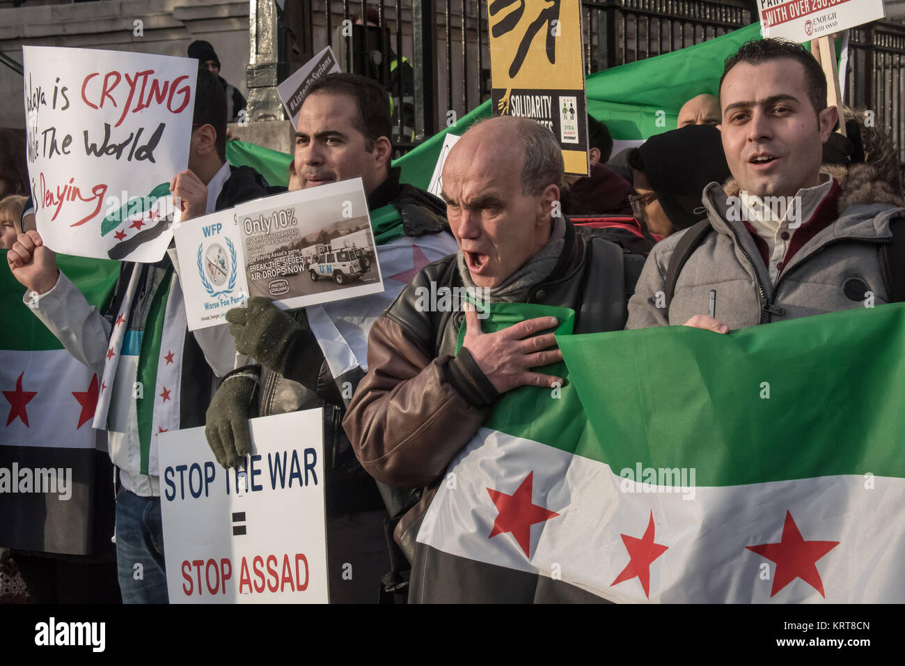 Manifestanti tenere le bandiere e poster e gridare slogan al 'Cibo non bombe' per la Siria protesta in Trafalgar Square. Foto Stock