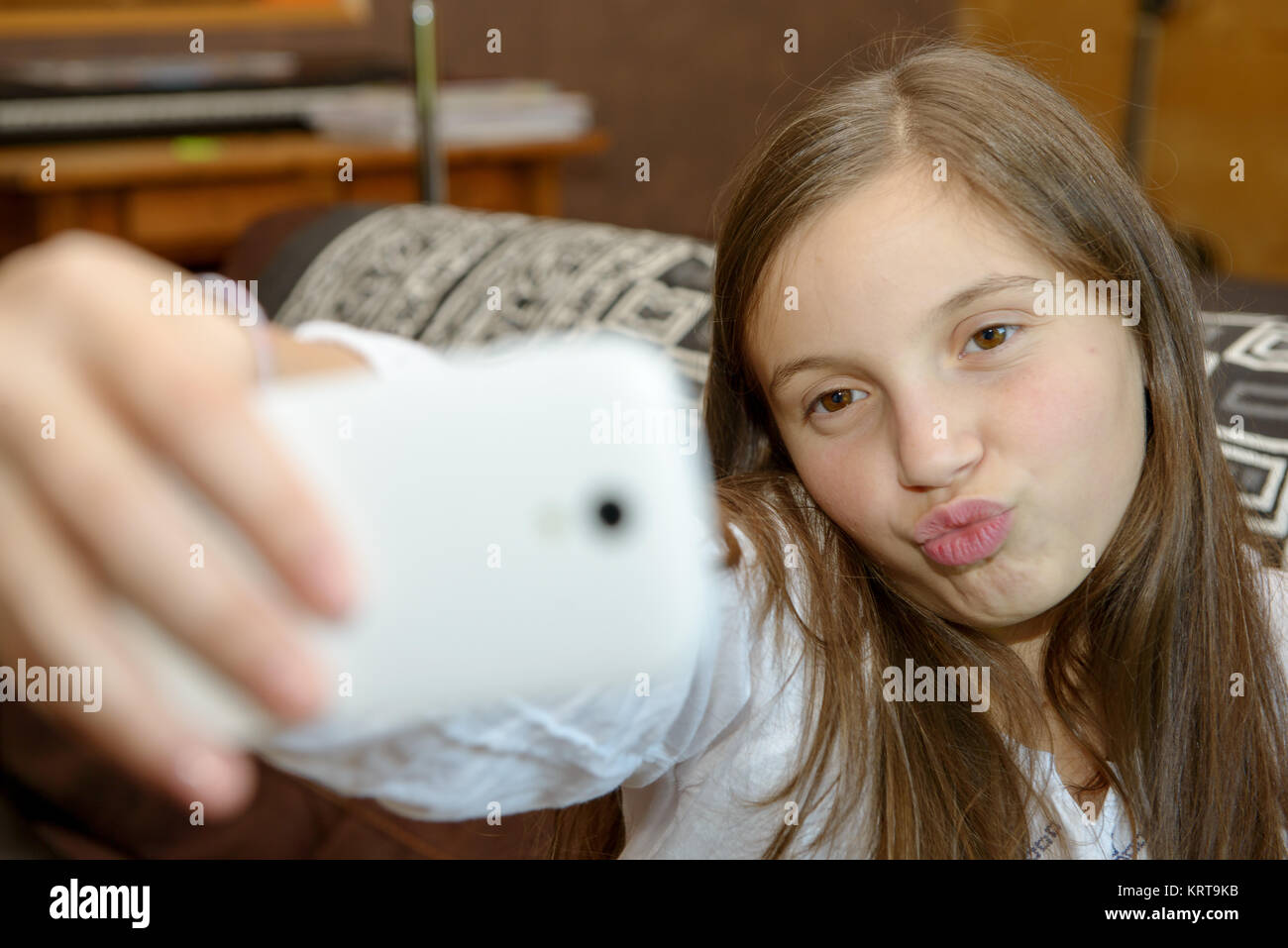 Giovane ragazza adolescente sul divano di casa il lettino tenendo selfie Foto Stock