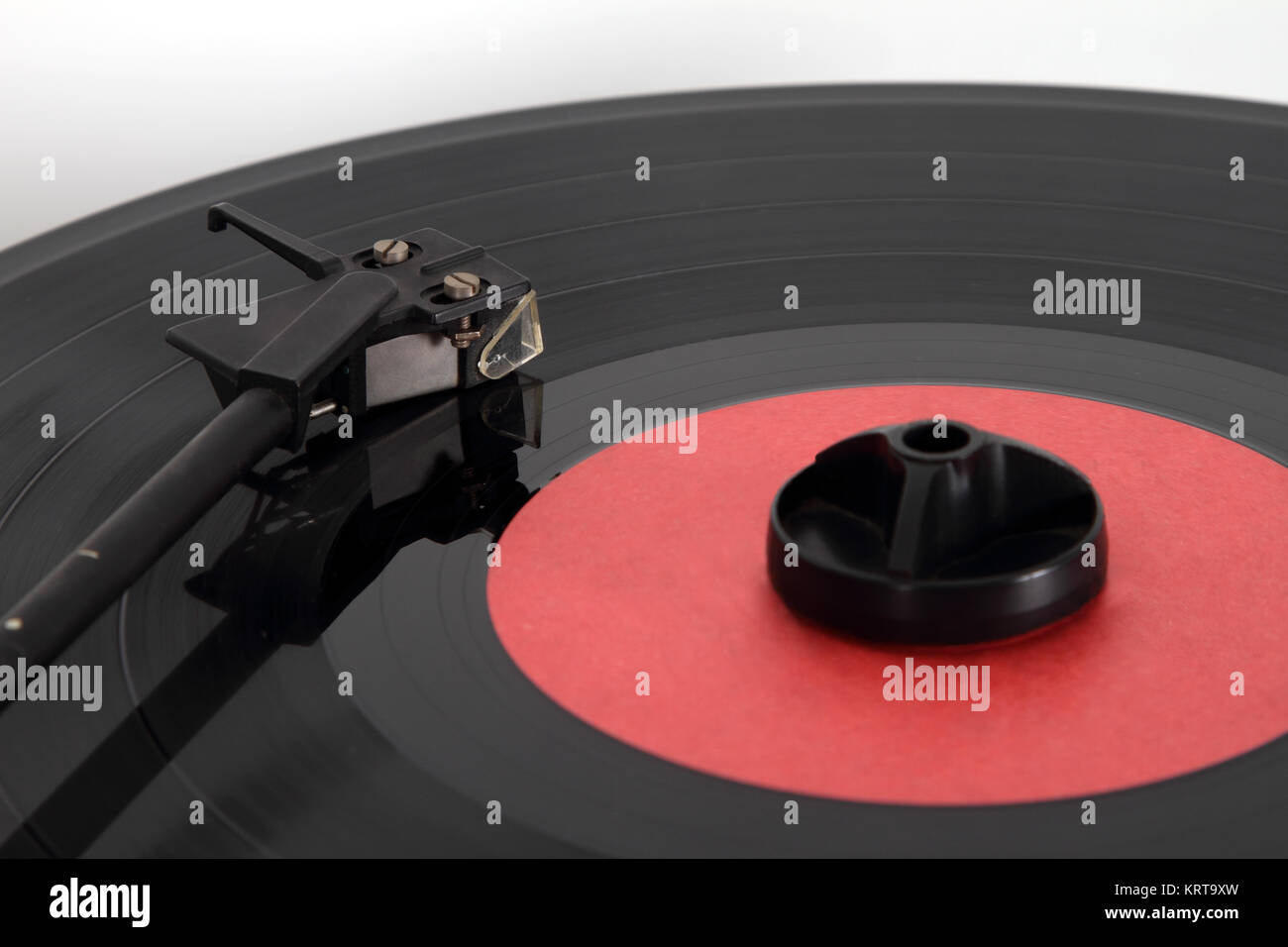 Ritiro e un disco in vinile con un tampone di pulizia giacente su di esso per rimuovere la polvere. Focus sulla testa di prelievo. Foto Stock