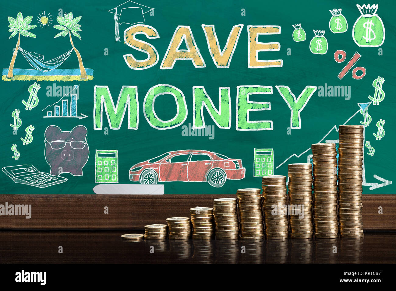 Monete impilate nella parte anteriore di Blackboard Foto Stock