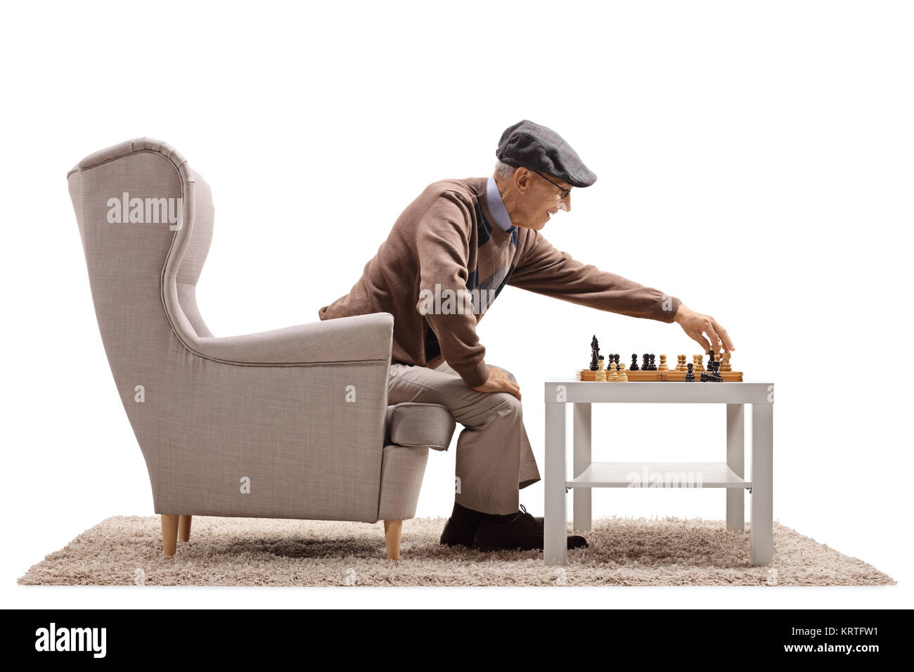 Senior seduto in poltrona a giocare una partita a scacchi con se stesso isolato su sfondo bianco Foto Stock