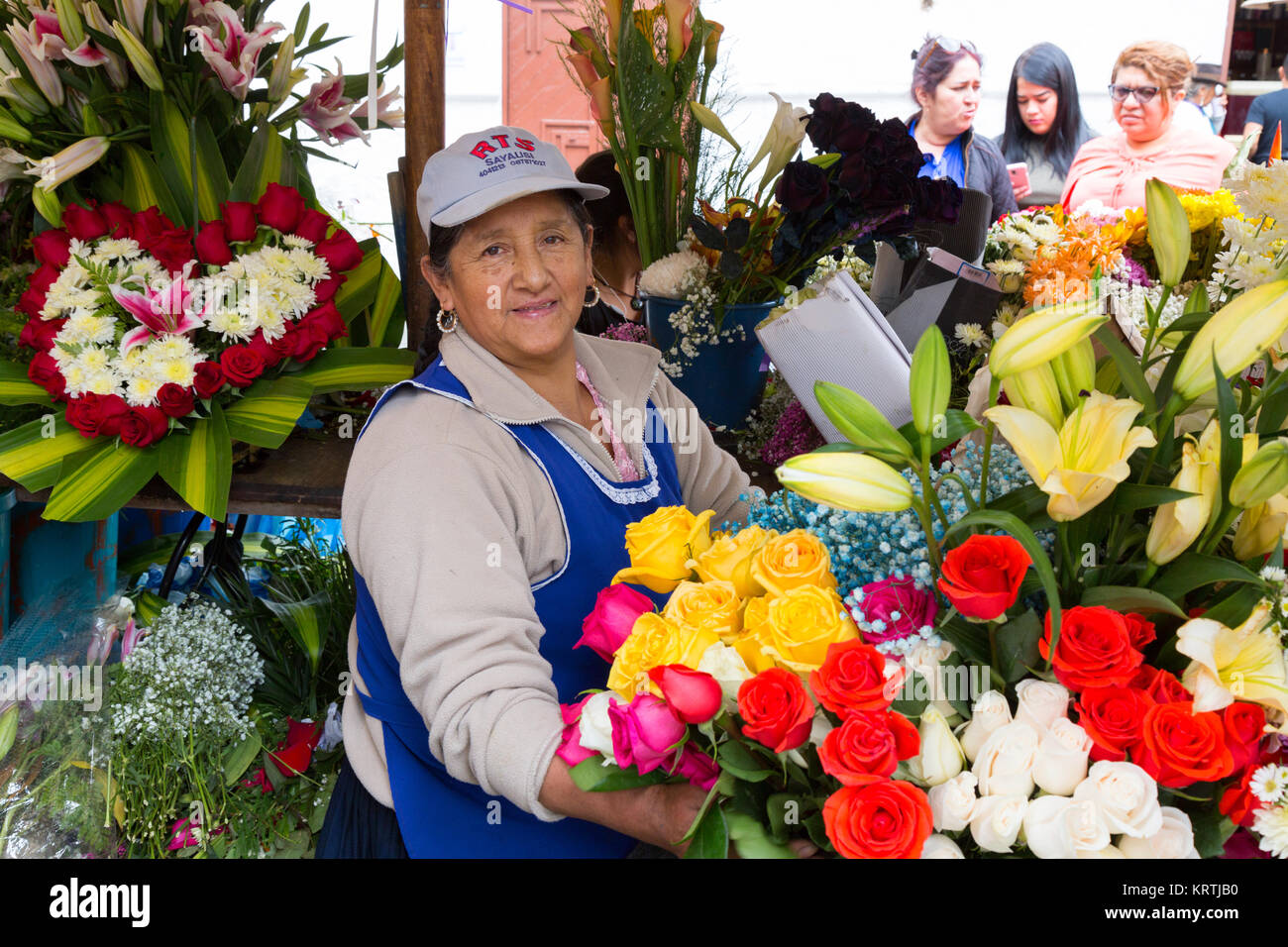 Ecuador Cuenca stallholder e portare in posizione di stallo, Cuenca il mercato dei fiori, Cuenca city centre, Cuenca Ecuador America del Sud Foto Stock