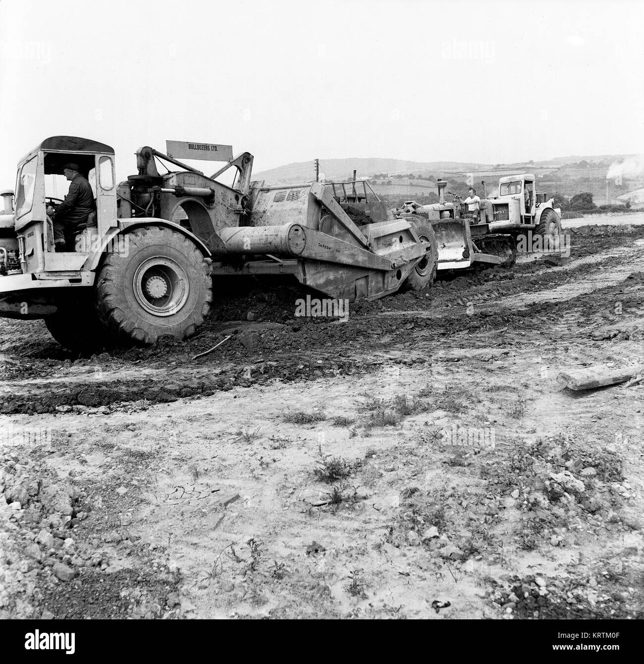 Movimento terra veicoli escavatore la preparazione di massa di alloggiamento per lo sviluppo immobiliare costruzione in Telford Regno Unito 1968 Foto Stock