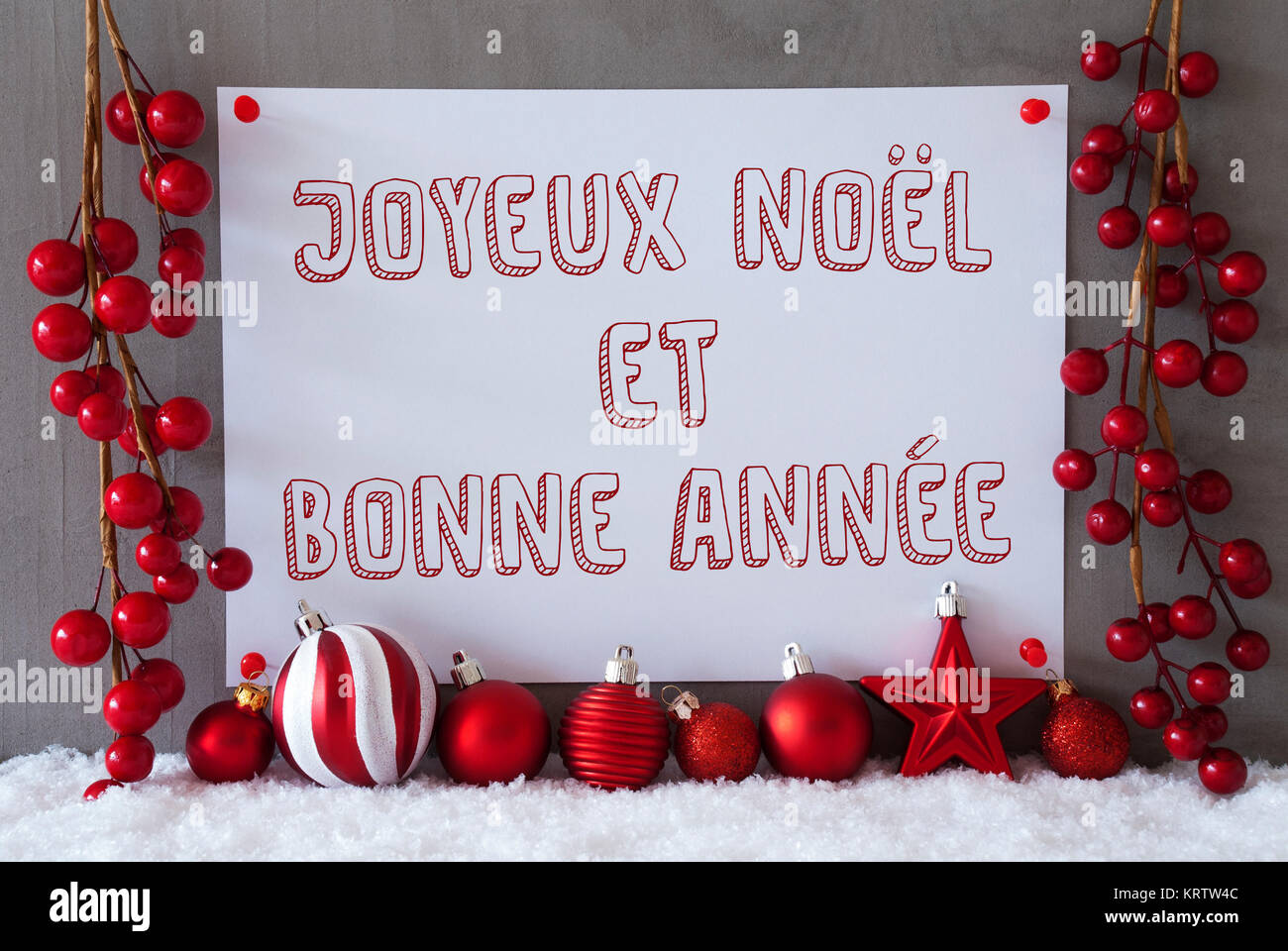 Etichetta con testo francese Joyeux Noel et bonne Annee significa Buon  Natale e Felice Anno Nuovo. Red decorazione di Natale come sfere sulla  neve. Urbano moderno e parete in cemento come sfondo