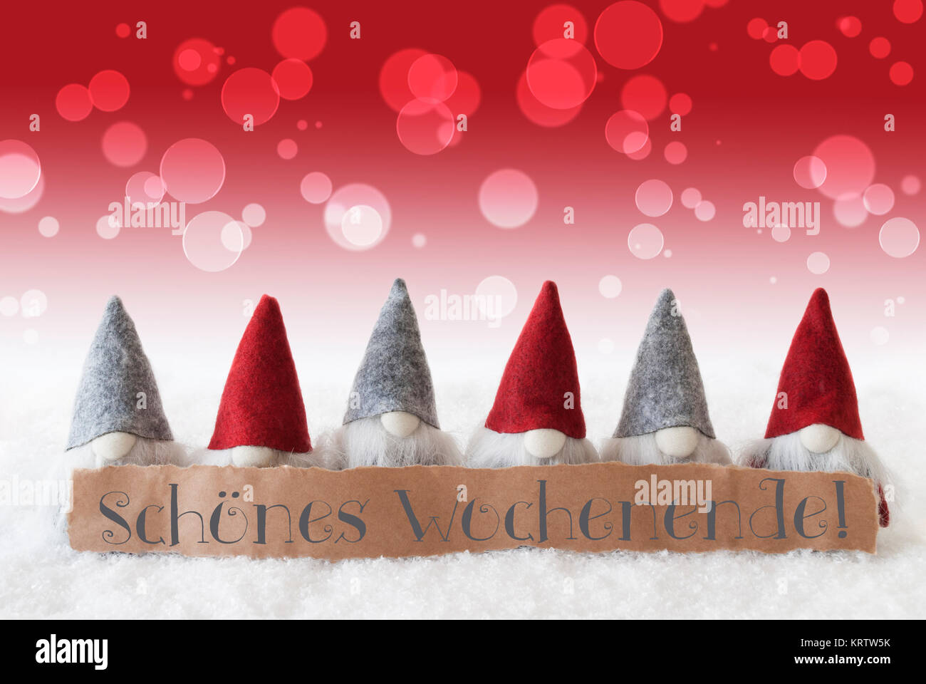 Etichetta con testo tedesco Schoenes Wochenende significa Happy Weekend. Natale biglietto di auguri con il rosso gli gnomi. Bokeh e Christmassy sfondo con la neve. Foto Stock