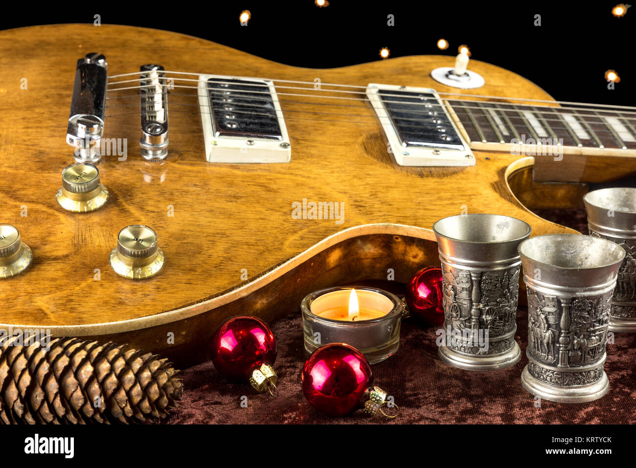 Chitarra elettrica decorata con Mug e candela a Natale Foto Stock