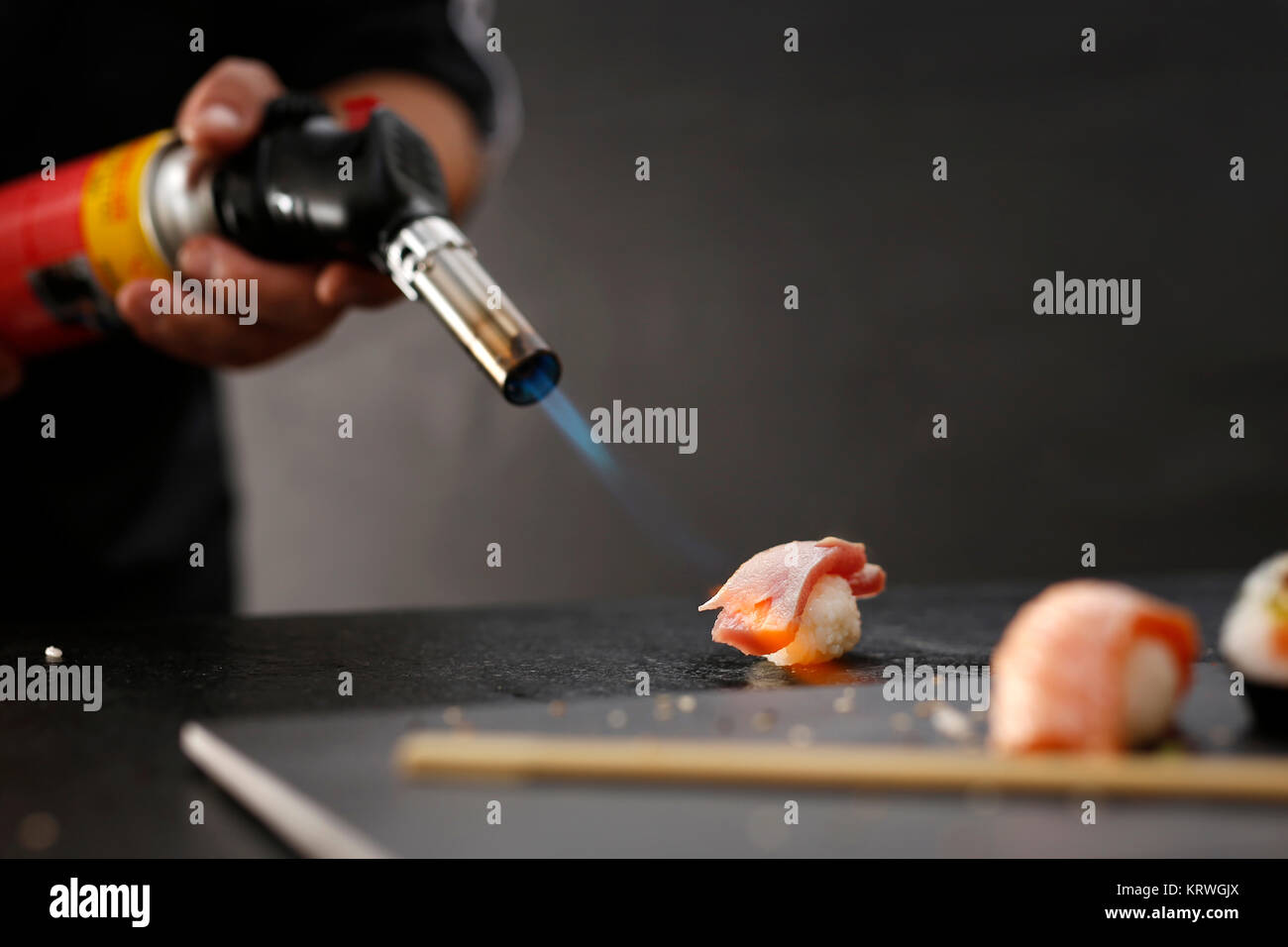 Sushi z surowym Å'ososiem opalane pÅ'omieniem. Porcja ryÅ¼u uformowanego w kulkÄ™ kawaÅ przykrytego'kiem ryby Foto Stock