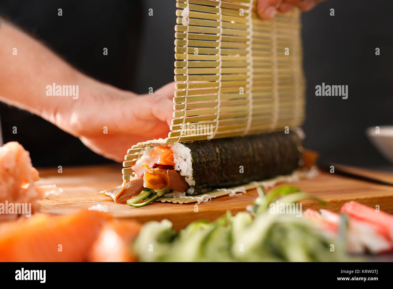 Mata bambusowa, przygotowywanie sushi. Jak przygotowaÄ‡ sushi. SkrÄ™canie rolki sushi w matÄ™ bambusowÄ… Foto Stock