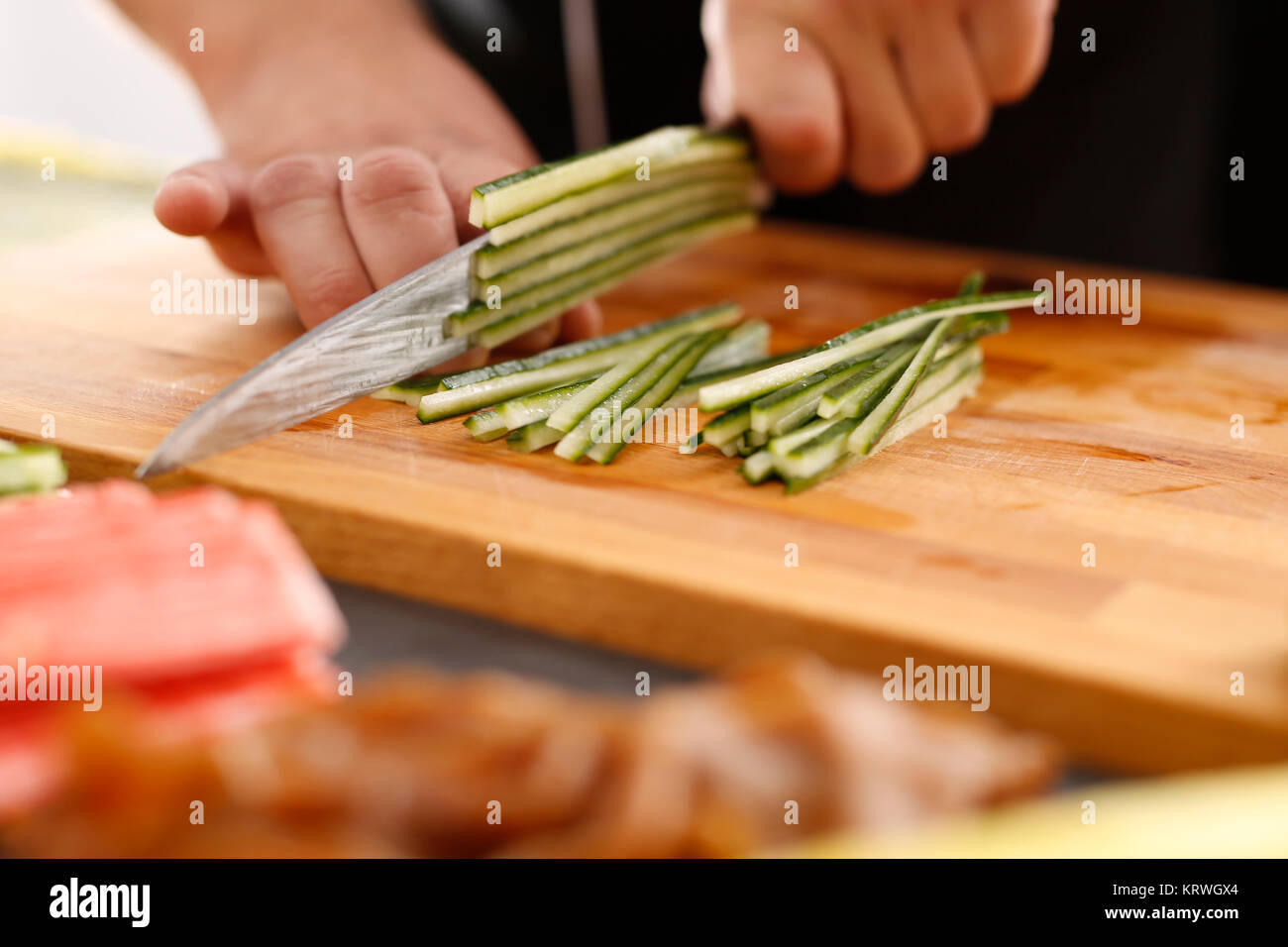Sushi , etapy przygotowywania sushi z Å'ososiem, paluszkiem krabowym, ogÃ³rkiem tykwÄ… zawiniÄ™tego w glon nori Foto Stock