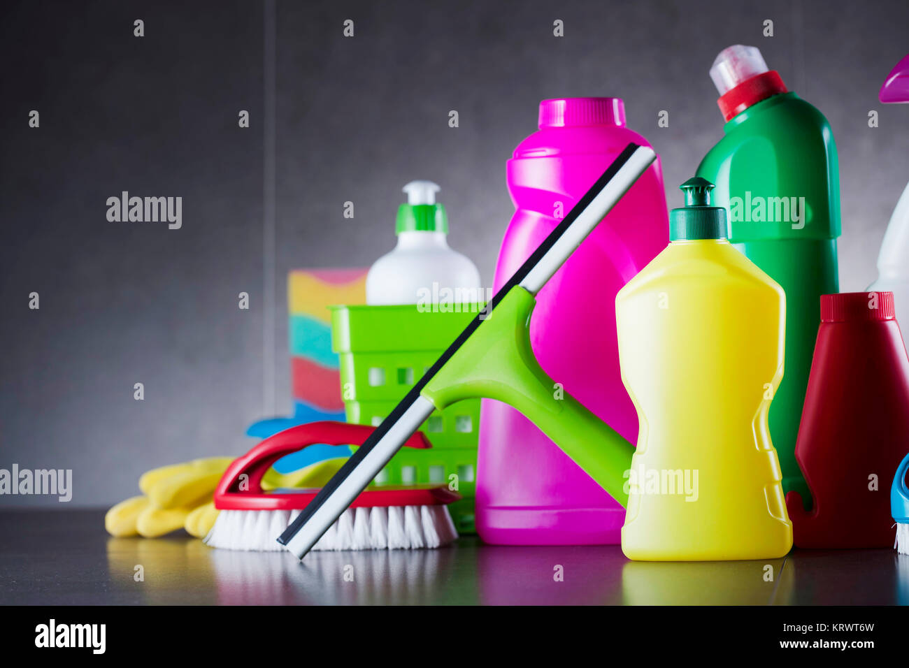 Insieme colorful di home prodotti di pulizia sulle piastrelle grigie. Posto per la tipografia. Foto Stock