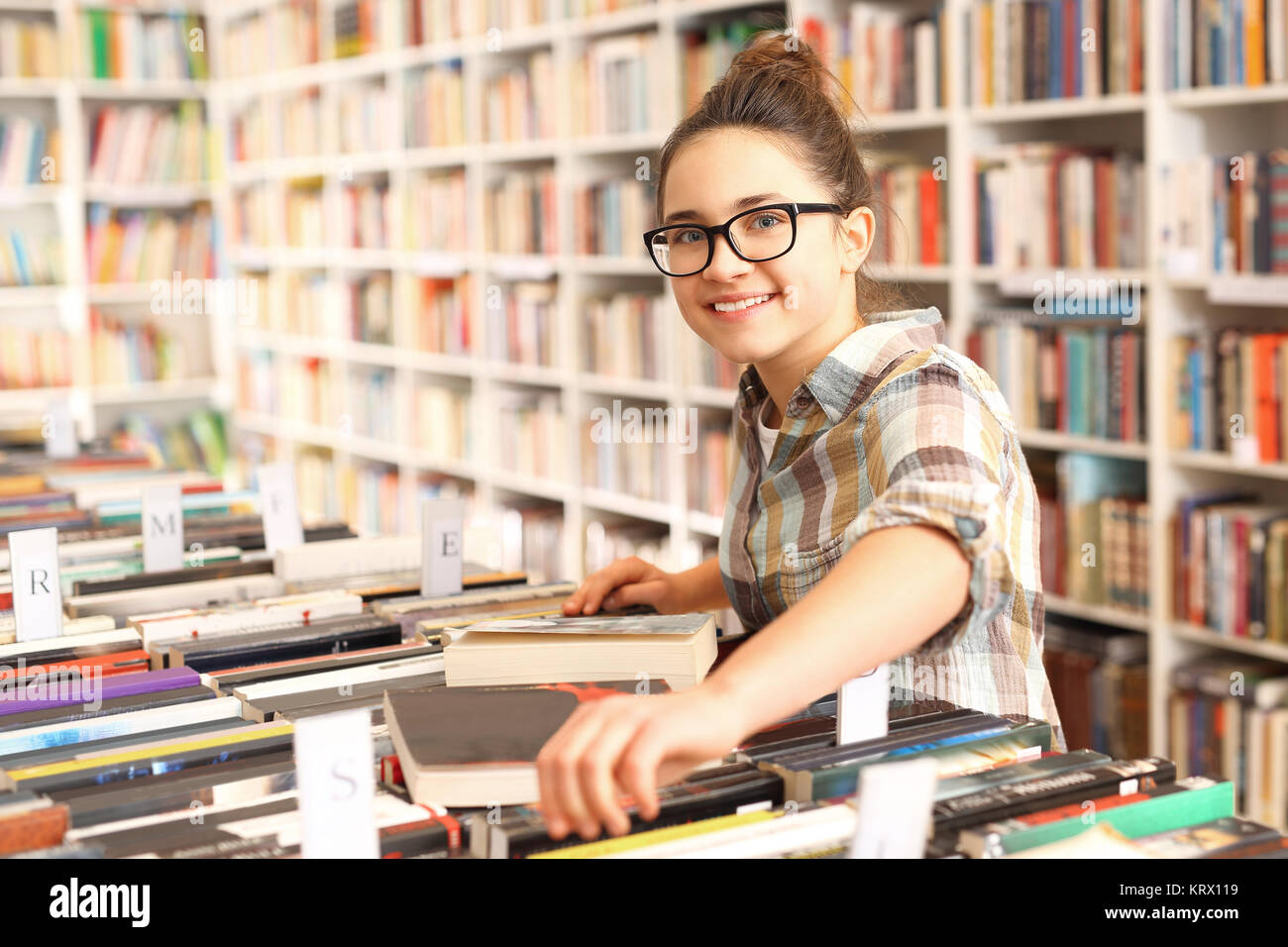 La ragazza sceglie un libro in una libreria. schoolgirl nella libreria. Foto Stock
