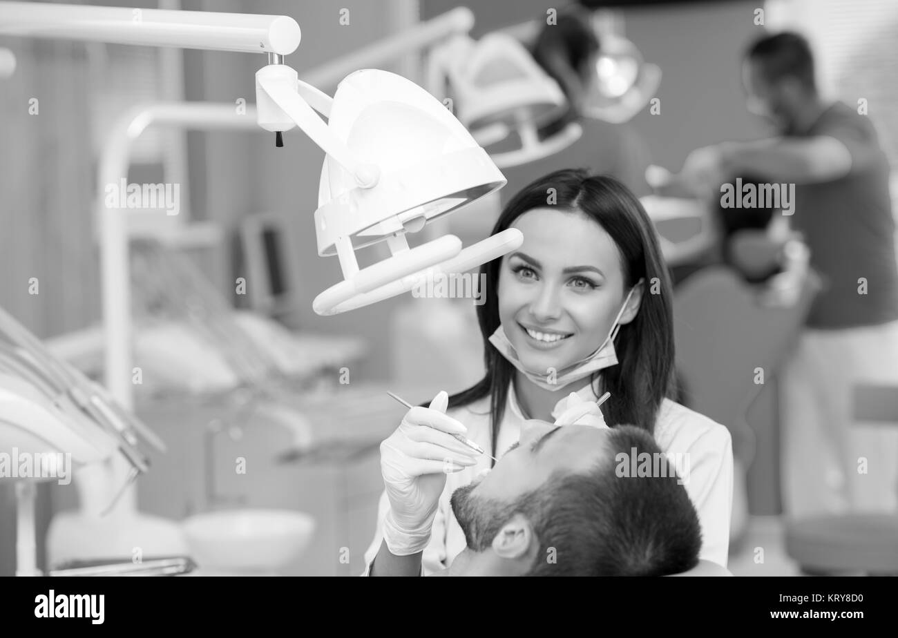 Dentista esaminando una denti del paziente al dentista. Foto Stock