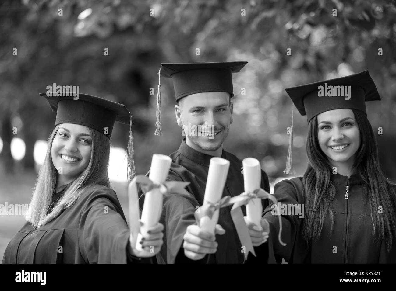 Istruzione, graduazione persone concetto - gruppo di felice gli studenti internazionali in mortaio e schede di corso di laurea gli abiti con diplomi Foto Stock