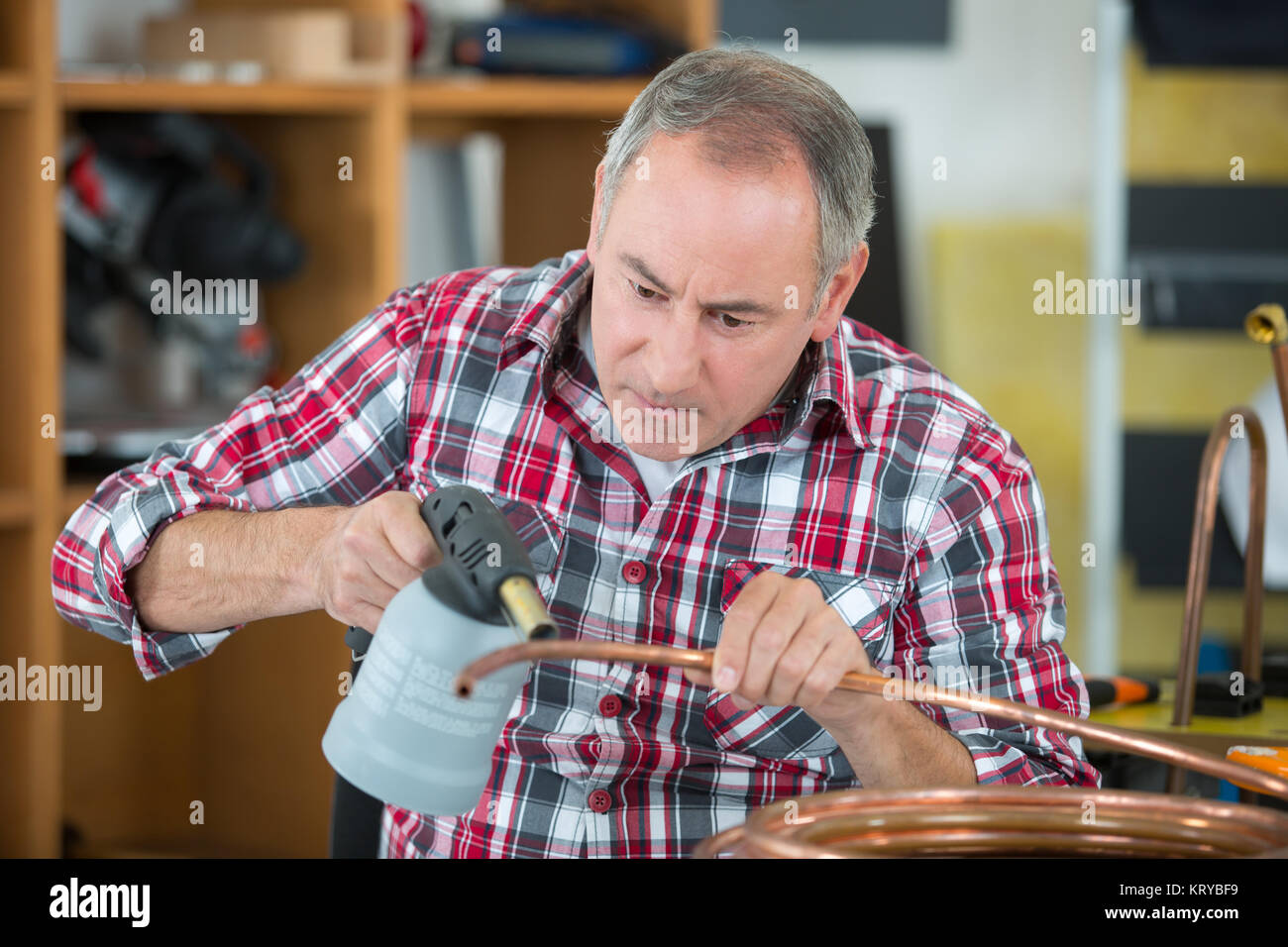 Lavoratore con cannello per la saldatura di raccordi in rame Foto Stock