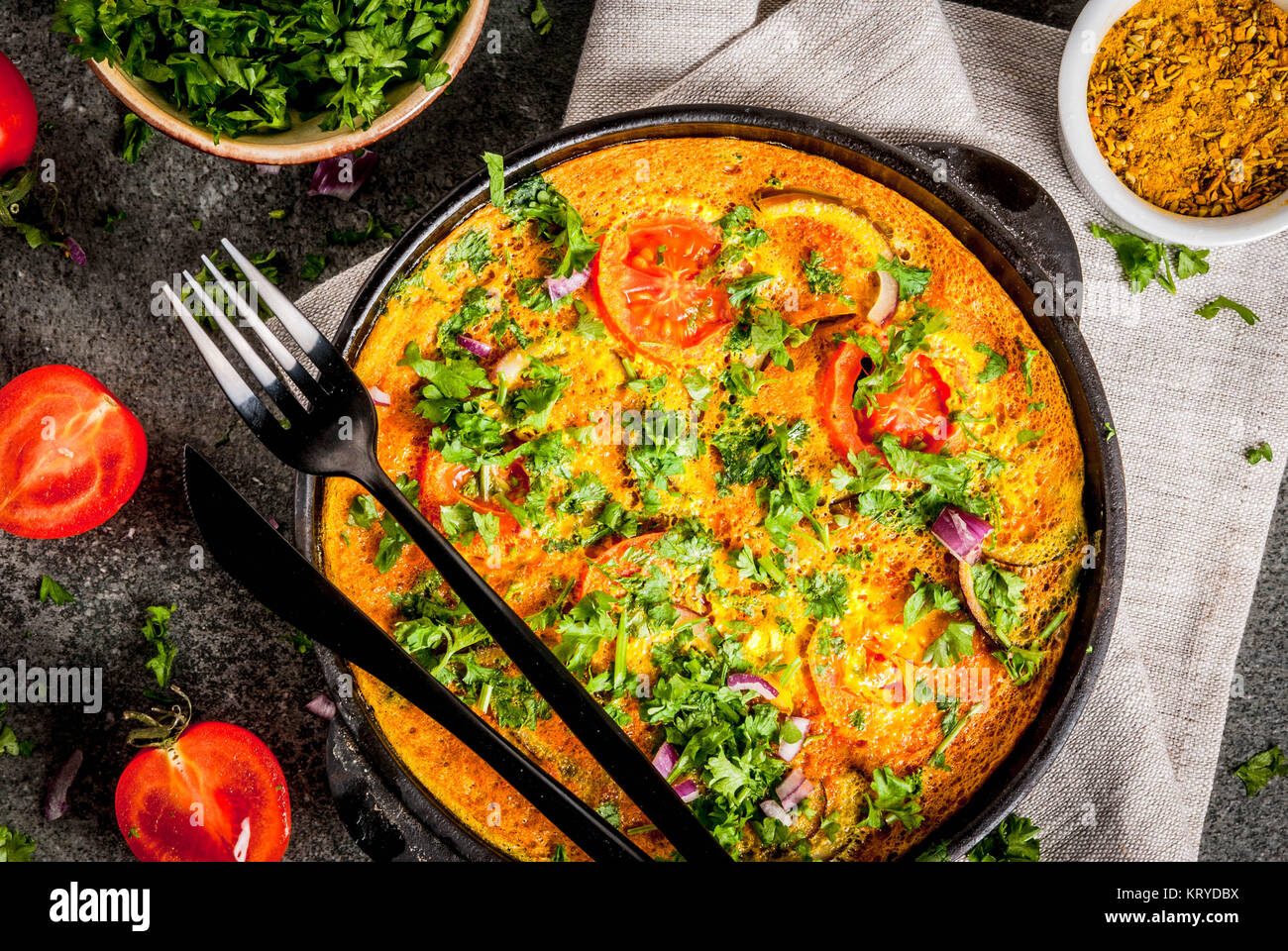 Il cibo indiano ricette, Masala frittata con verdure fresche - pomodoro, peperoncino, prezzemolo, pietra scura, sfondo spazio copia vista superiore Foto Stock